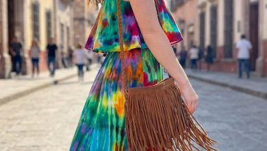 Vibrant tie-dye maxi dress, gladiator sandals, a fringe crossbody, and wide-brim hat combine for a bohemian summer casual outfit, ideal for music festivals or outdoor concerts.