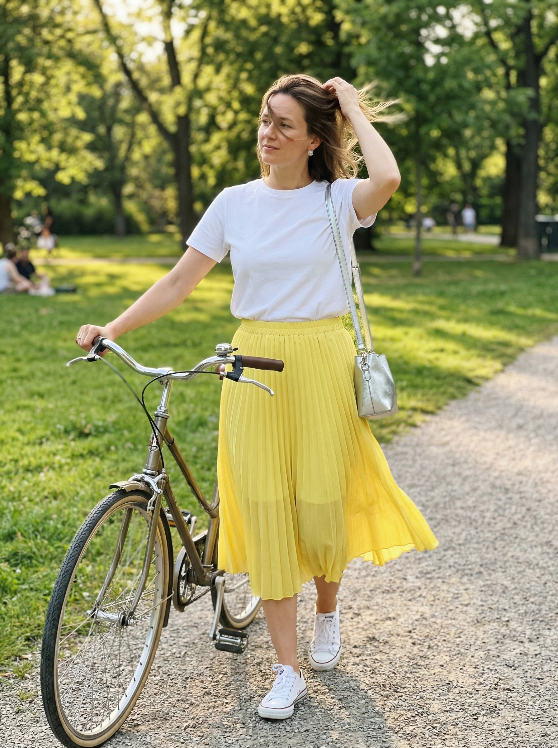 Playful colorful summer outfits 2026 for a picnic featuring a lemon yellow pleated midi skirt, white tee, low-top sneakers, and a silver crossbody bag.
