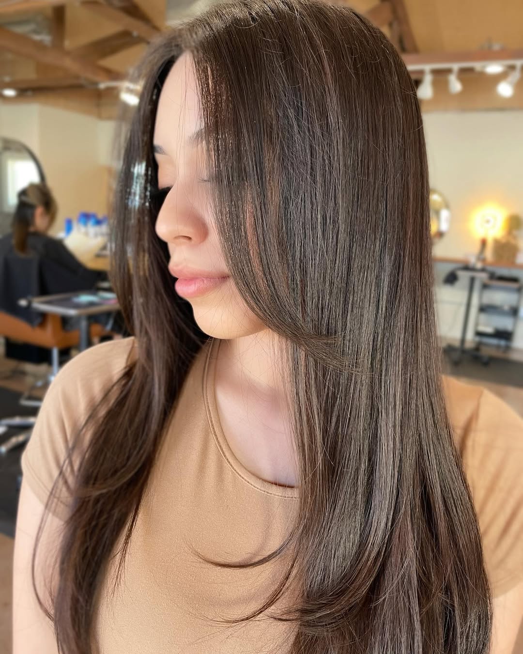 Woman with long, wavy blonde hair styled in loose beach waves, perfect for cool summer hair ideas. Her hair catches the light beautifully, suggesting natural movement and a relaxed vibe.