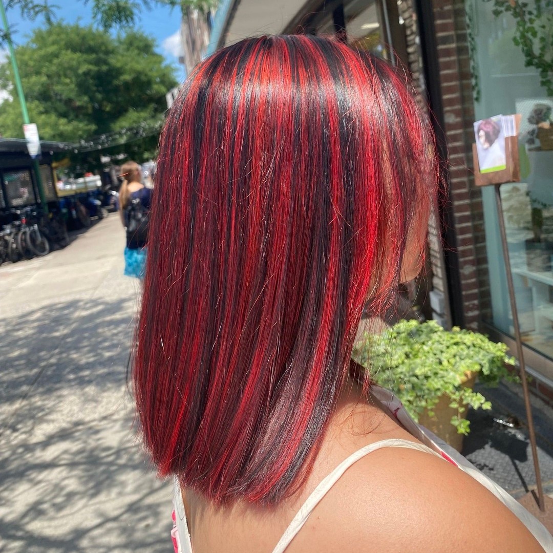 Close-up of a woman with long, sun-kissed brown hair styled in soft, beachy waves, perfect for cool summer hair ideas 2026. Her hair has subtle golden highlights, framing her face beautifully, ideal for a casual day or evening out.