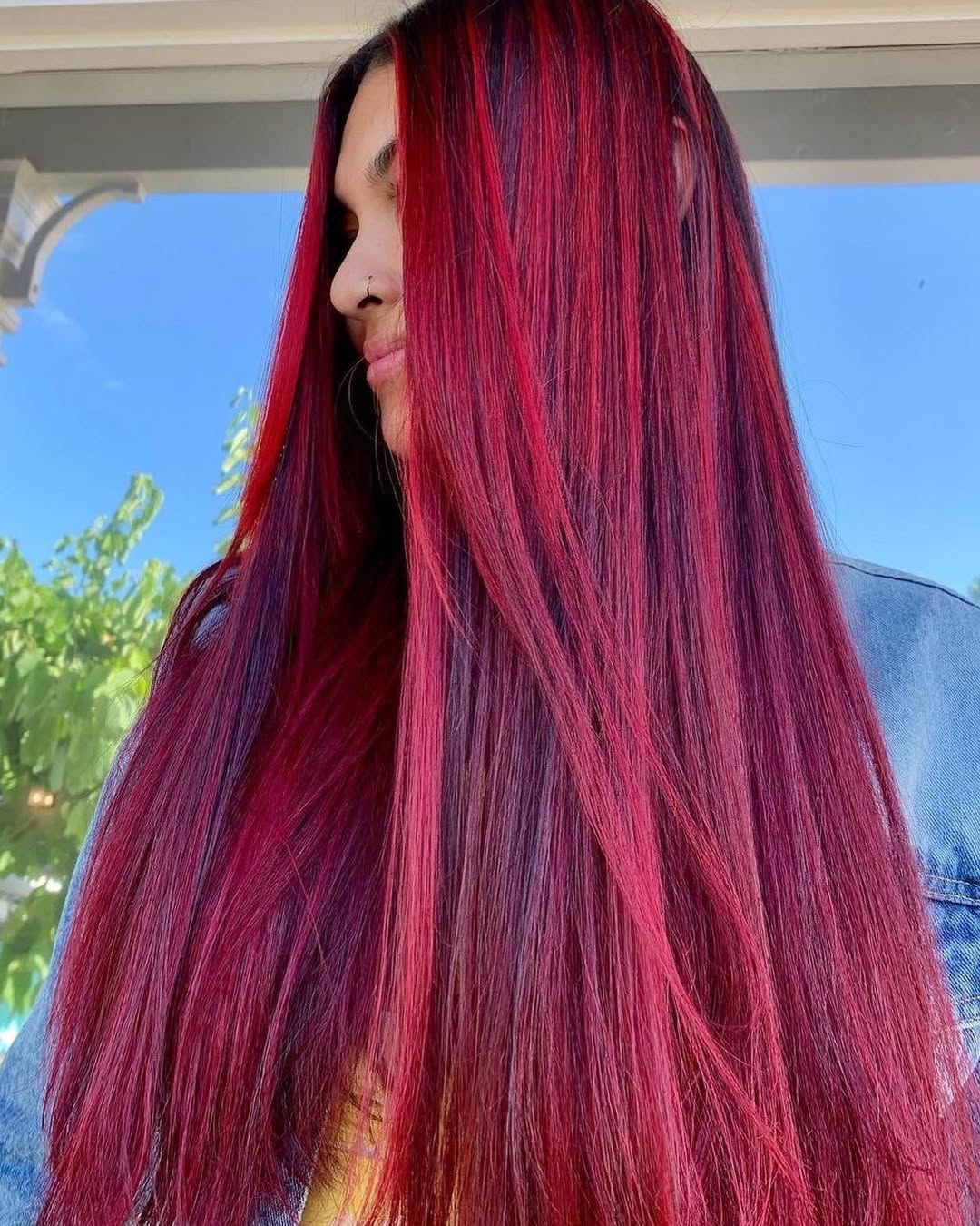 Close-up of a woman with cool summer hair ideas 2026, featuring a messy high bun with face-framing tendrils for a casual day out.