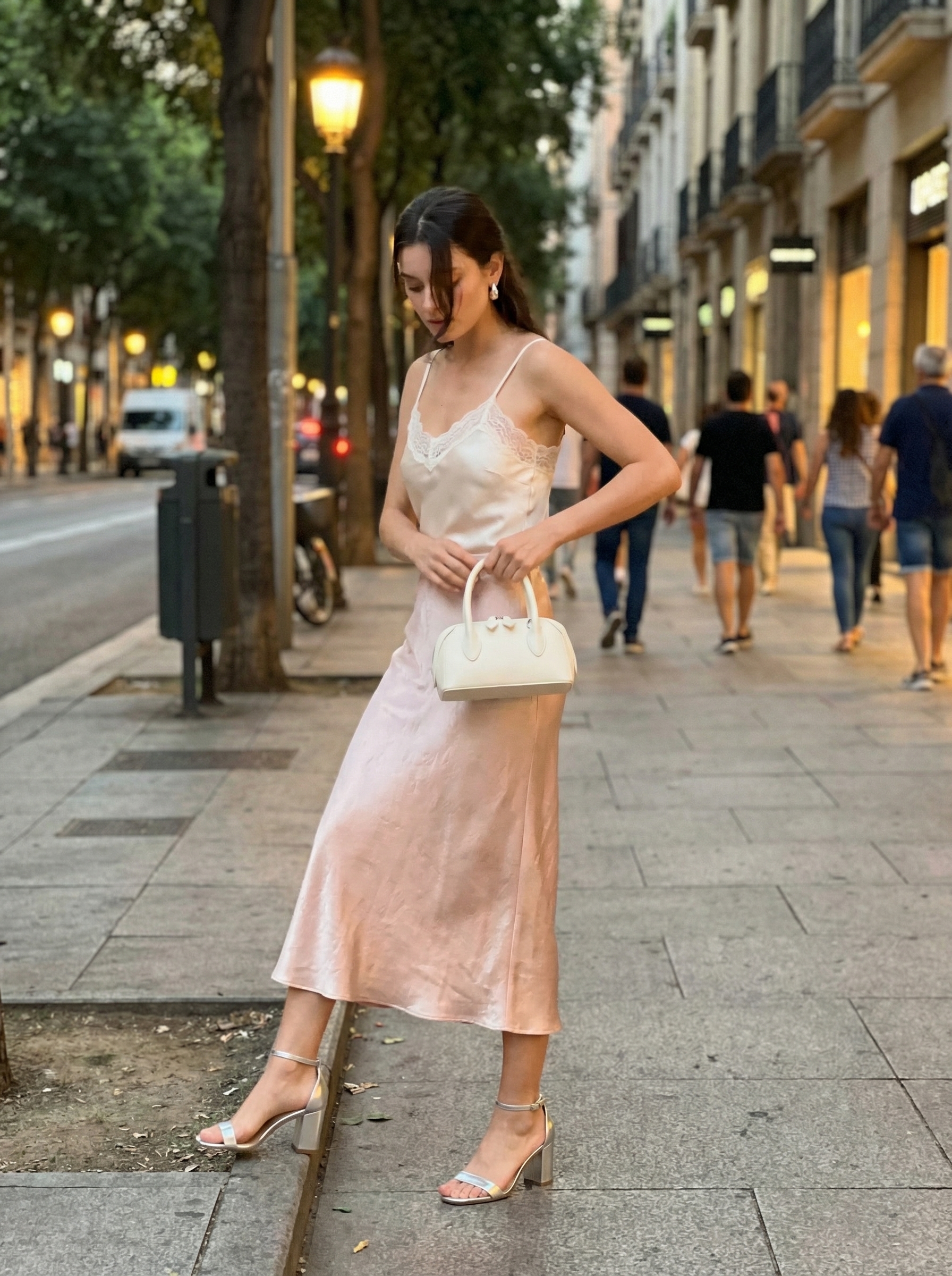 Romantic Summer Date Outfit 2024 A romantic outfit with a blush pink satin bias-cut midi skirt, an off-white lace-trimmed camisole, silver strappy block heels, and a mini top-handle bag, showcasing cute comfy outfits for summer dates.