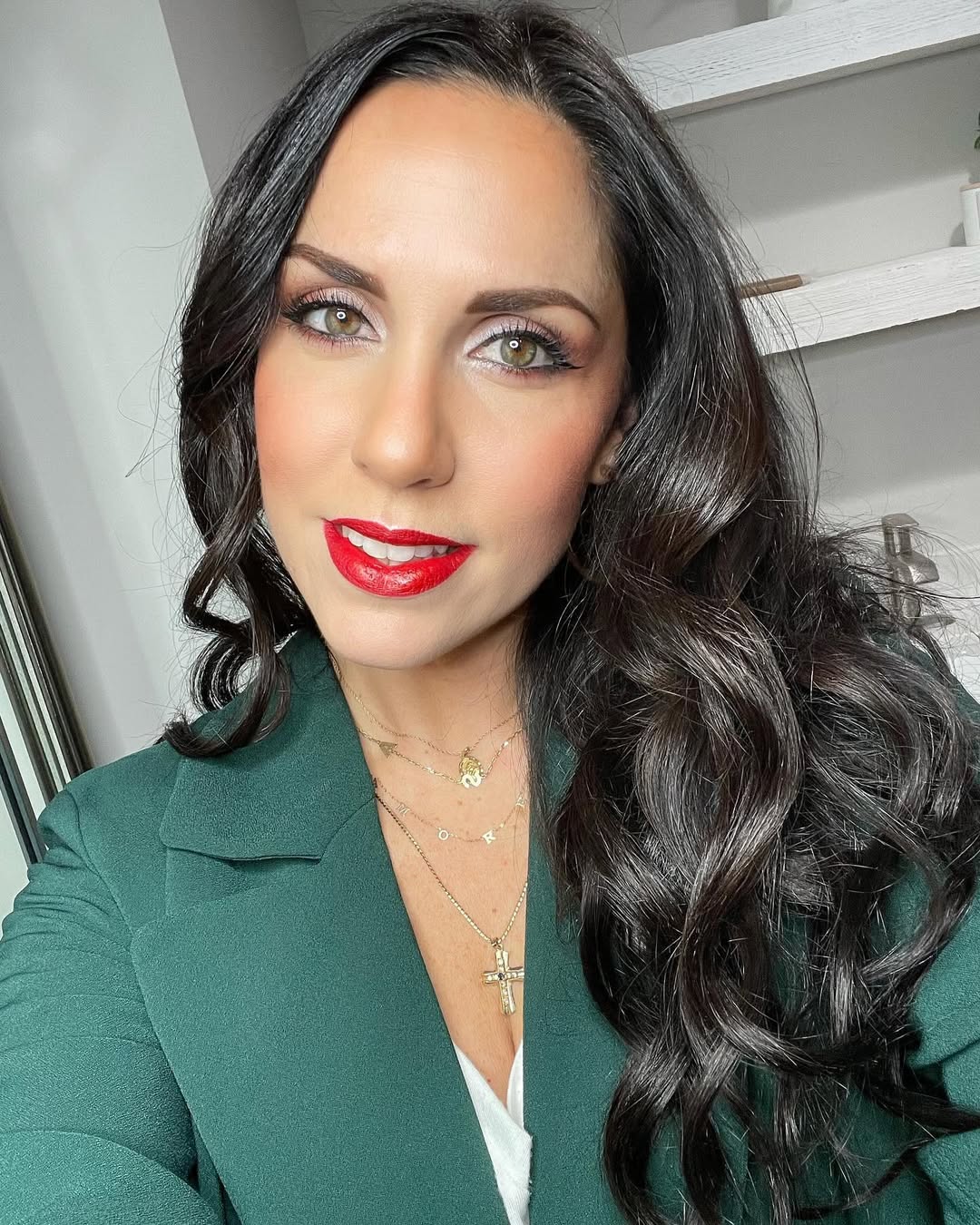 A woman with long, dark, wavy hair styled with subtle auburn highlights, perfect for dark summer hair ideas 2026. She wears a casual white sundress, smiling softly in natural light, showcasing healthy hair texture.