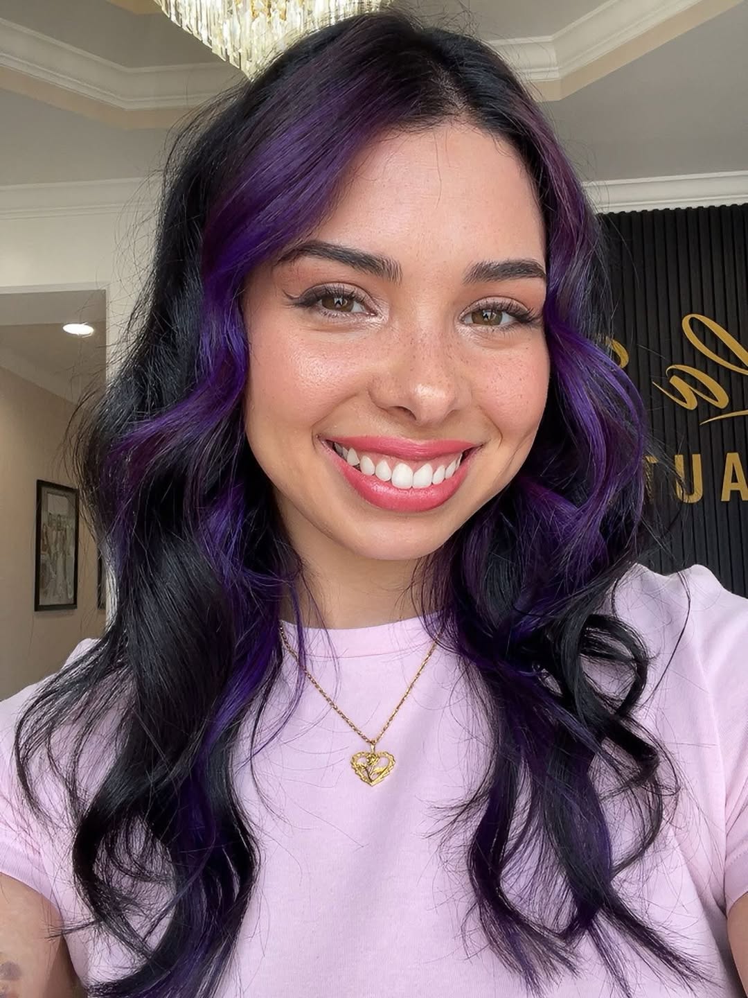 Woman with long, wavy dark summer hair ideas 2026, styled with subtle face-framing highlights, wearing a white linen dress for a casual beach day.