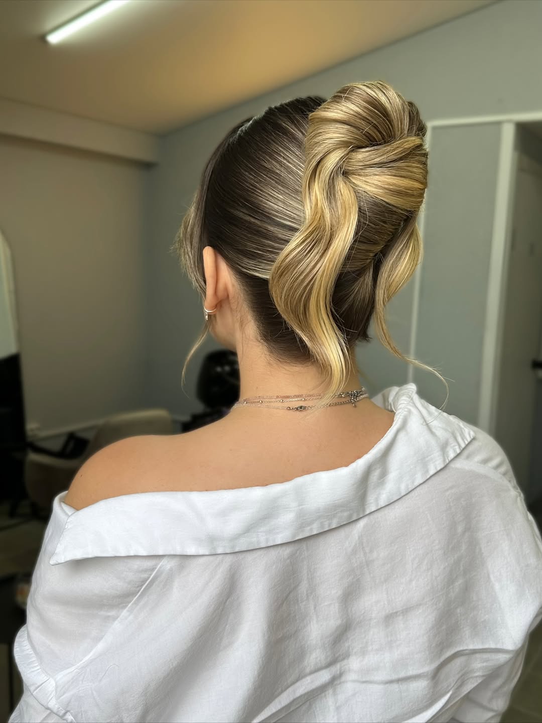 A woman wears a casual braided crown, perfect for easy summer hairstyles 2026. Her dark hair is styled in a delicate, relaxed braid circling her head, suitable for a daytime outing or beach trip.