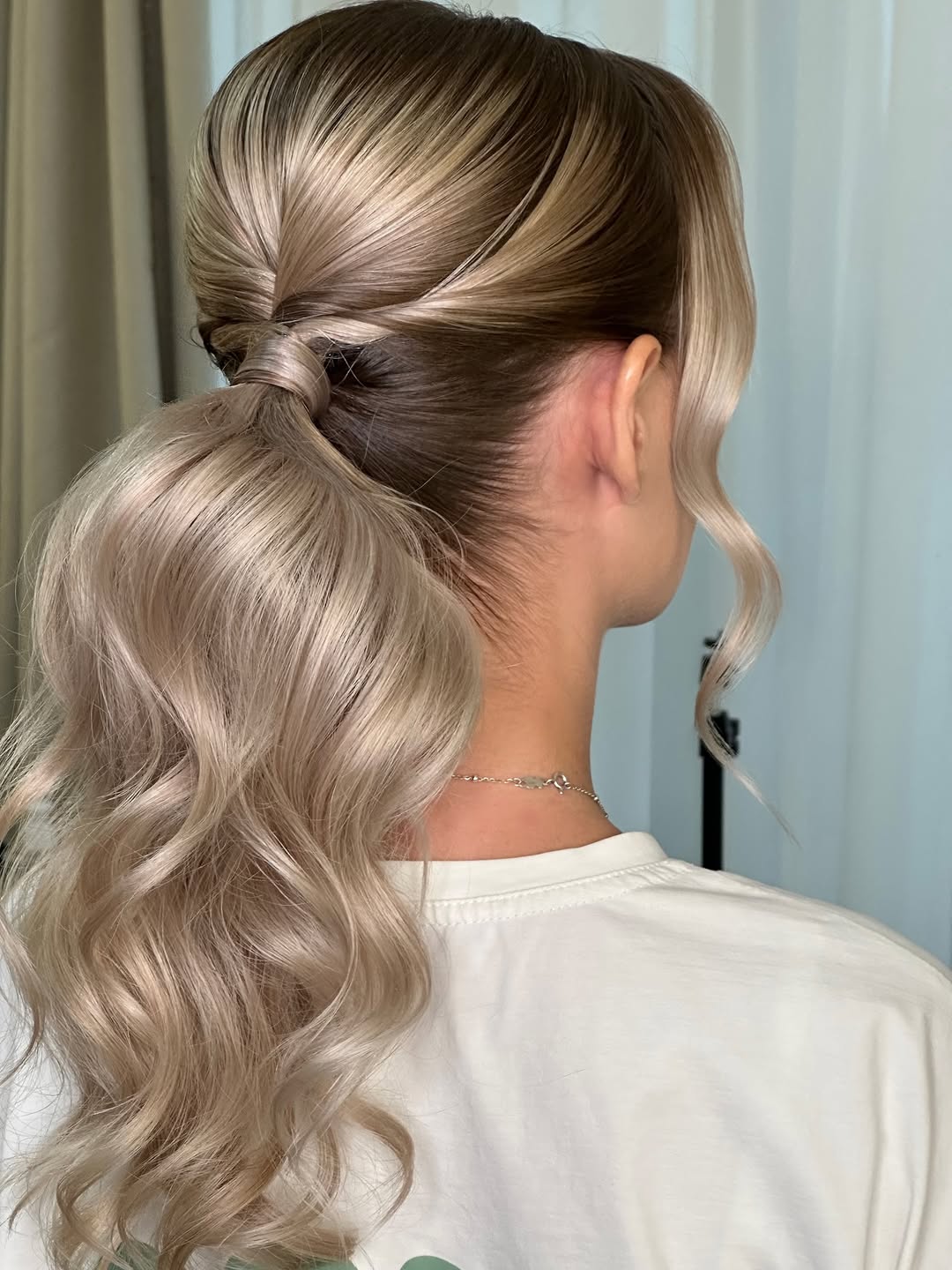 Blonde woman with a braided half-updo, showcasing easy summer hairstyles 2026. Perfect for a casual daytime look or beach outing.