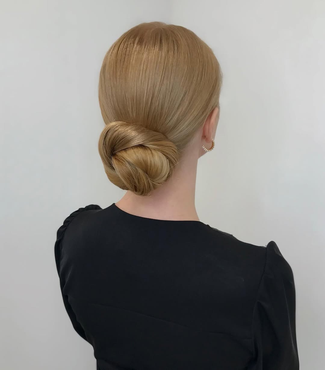 A woman confidently poses with an elegant braided updo, showcasing one of the easy summer hairstyles 2026. Perfect for a chic garden party or upscale brunch.