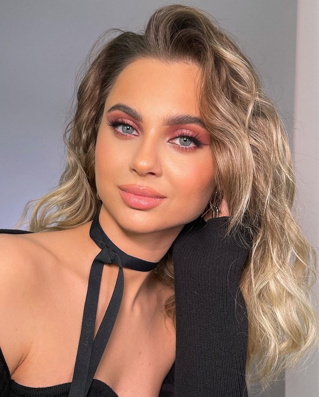 Woman with a chic low bun, adorned with delicate pearl clips. This easy summer hairstyle 2026 is perfect for a sophisticated brunch or evening event.