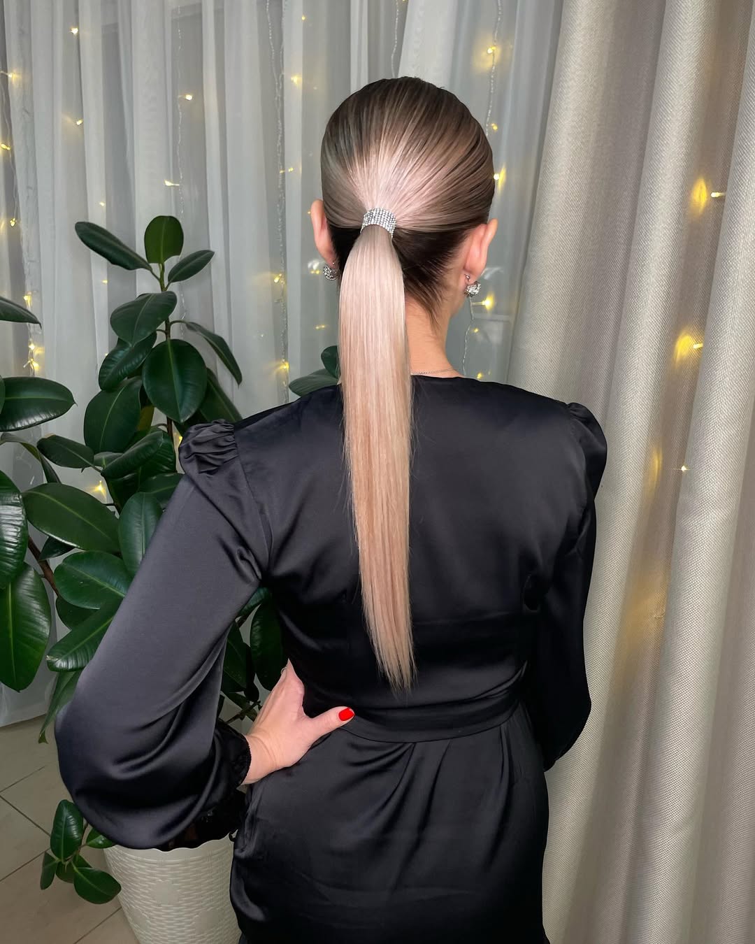 Woman with long, dark hair in a relaxed, side-swept braid ideal for easy summer hairstyles 2026. She wears a flowy white dress in a sunny outdoor setting.