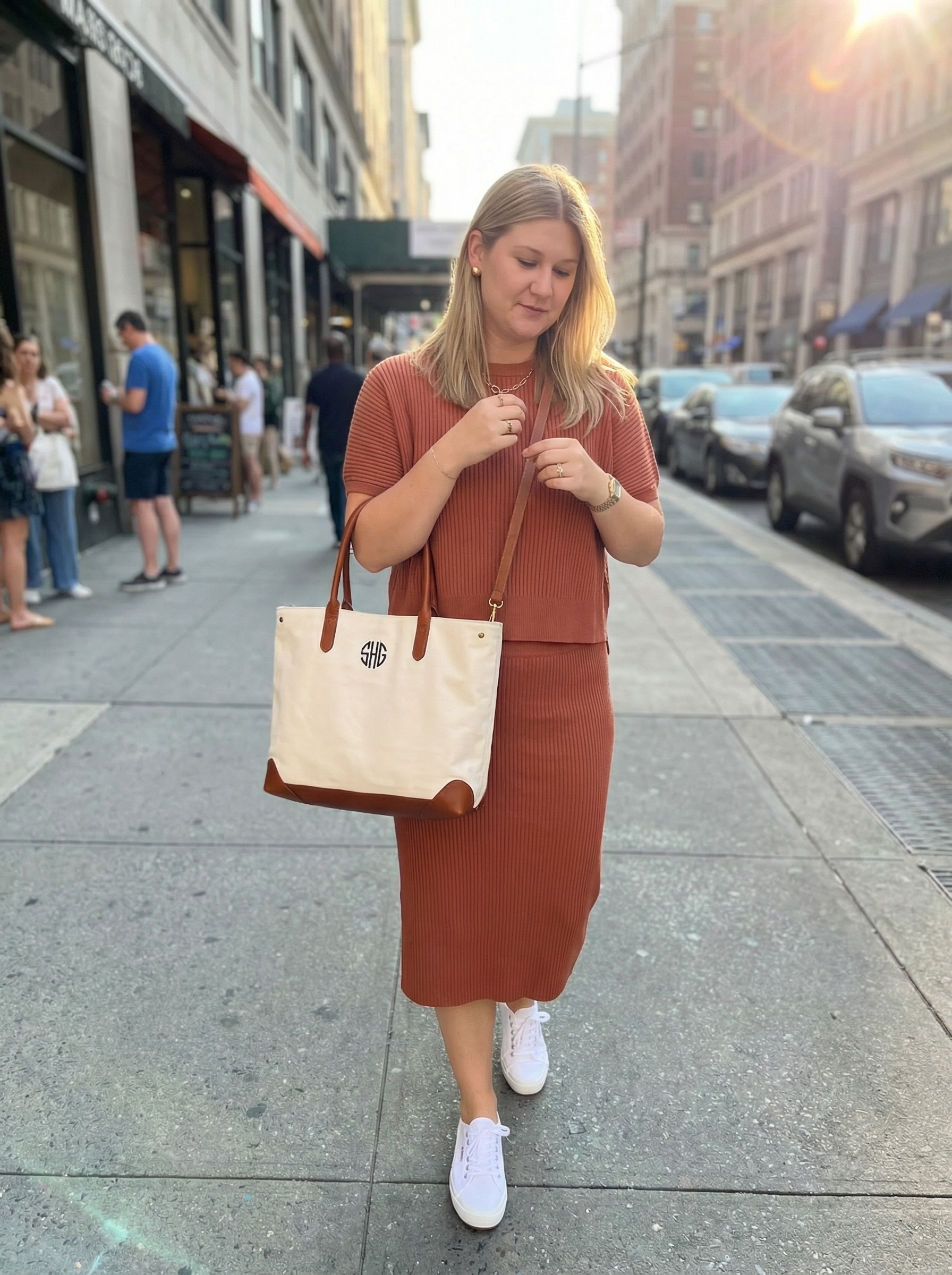 Cozy end of summer outfits for autumn transition: muted rust ribbed knit tank and midi skirt set, white sneakers, gold studs.