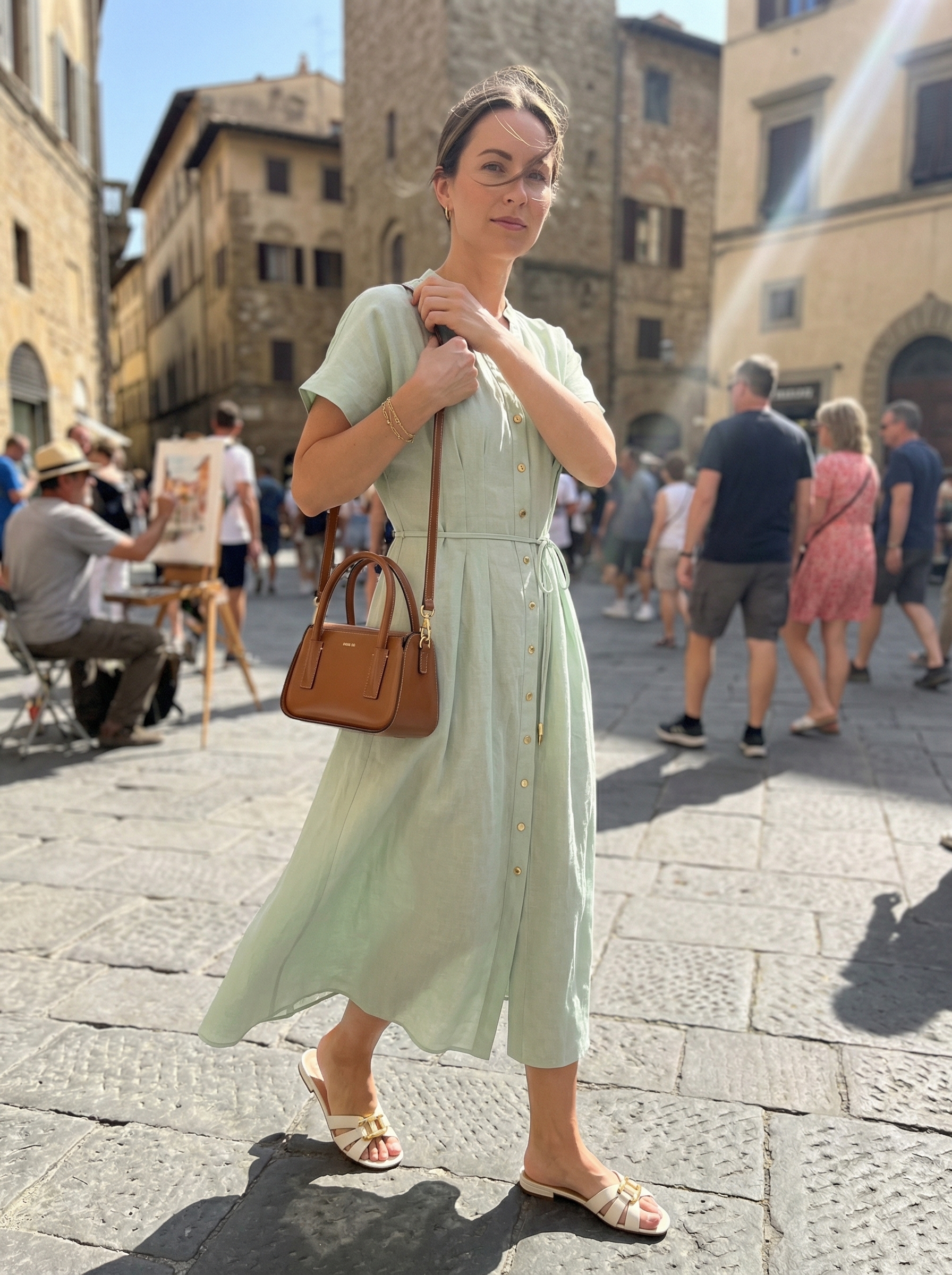 Serene Europe summer outfits for a Swiss lakeside retreat, featuring a sage green linen midi shirt dress, white leather slide sandals, a brown mini tote bag, and a delicate gold chain bracelet.