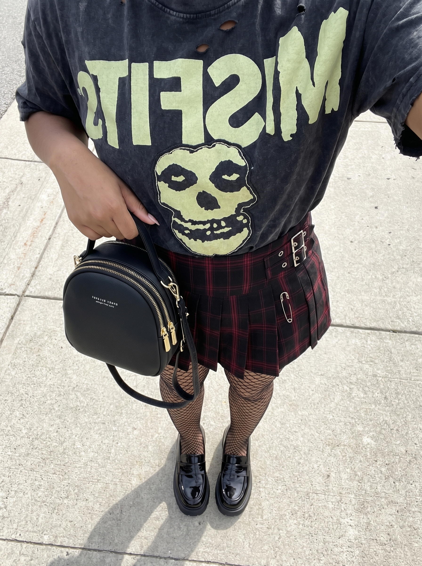 Edgy grungy summer outfit featuring a red and black plaid mini skirt, oversized graphic tee, fishnet tights, and platform loafers for a retro casual date.