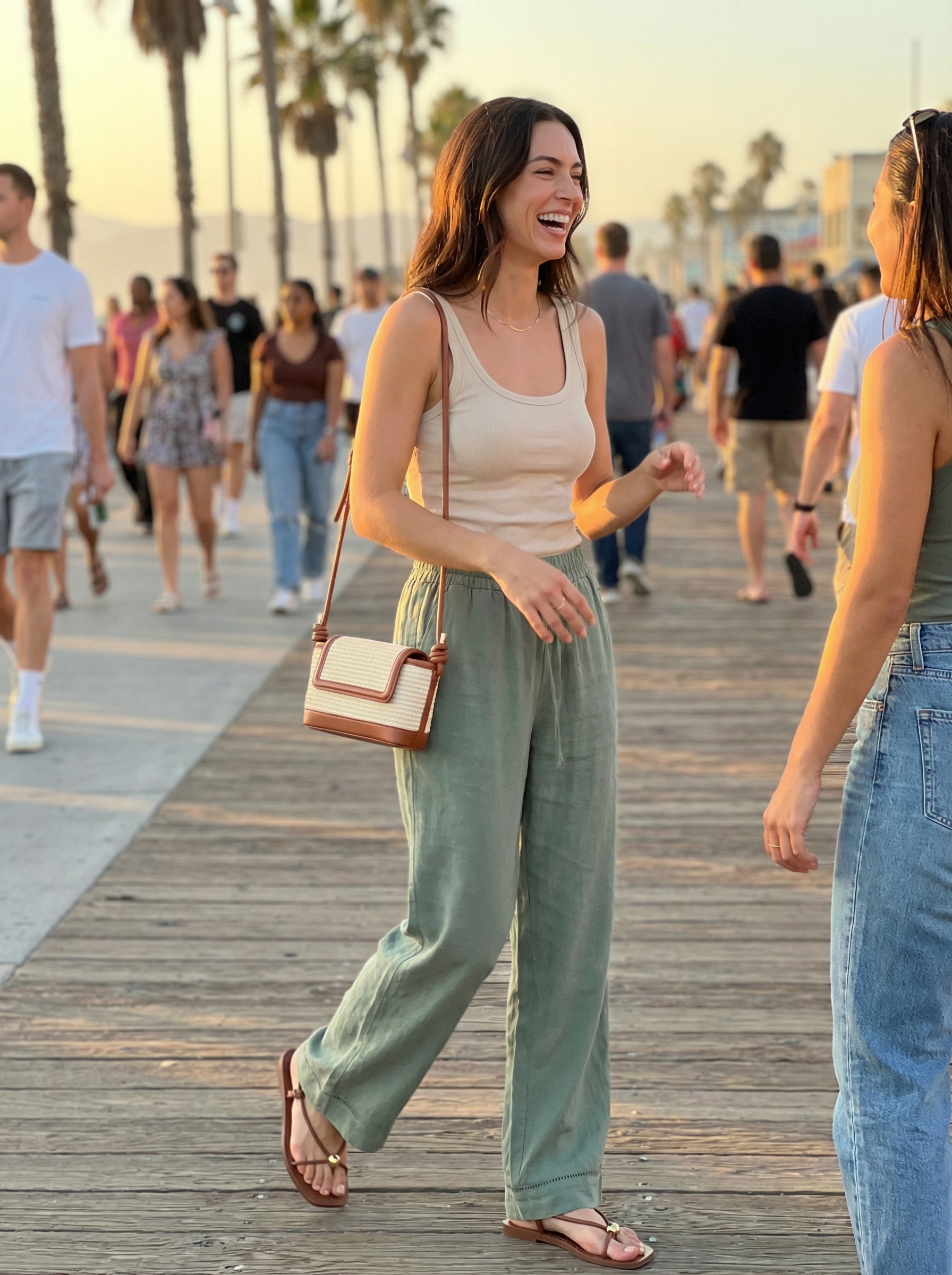 Relaxed late summer outfit with sage green wide-leg linen pants, a cream ribbed tank, tan strappy sandals, and a straw crossbody bag for an evening stroll.
