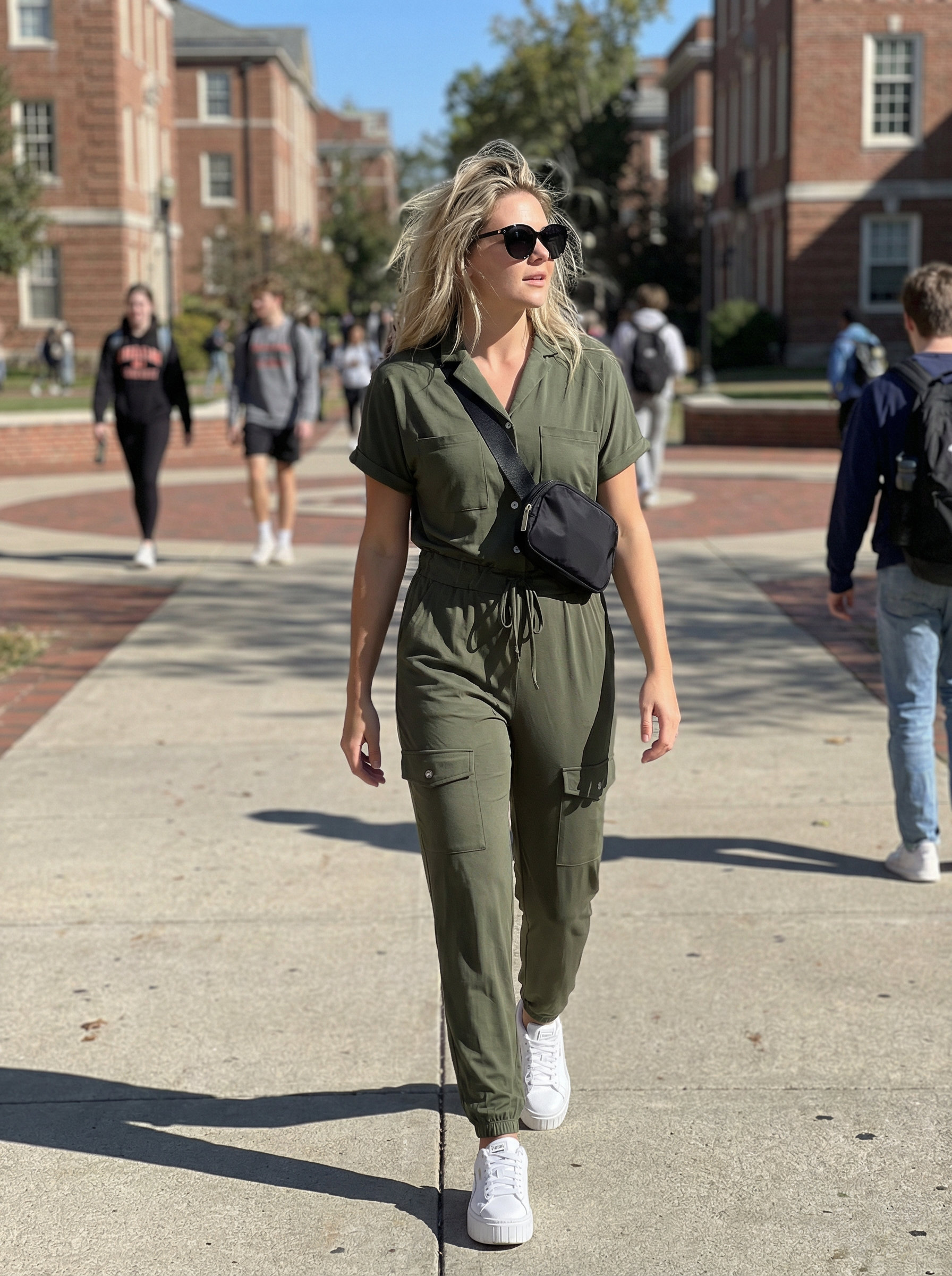 Energetic khaki green utility jumpsuit with white chunky sneakers and a black belt bag, perfect as a school summer outfit for a campus tour.
