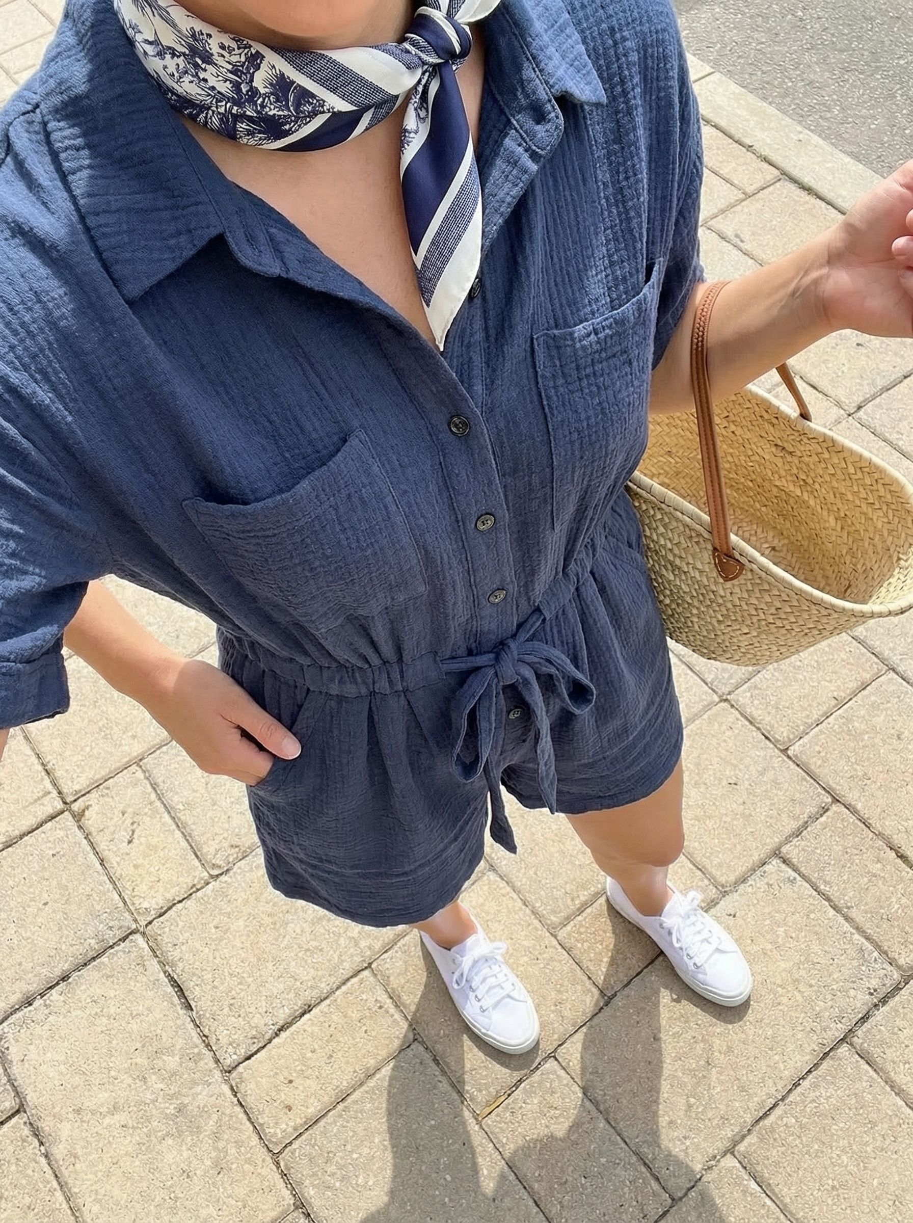 Simple Summer Outfits 2024: Chic Romper Style A comfortable 'Weekend Getaway Romper' simple summer outfit: navy linen romper, white canvas sneakers, straw tote, and bandana.