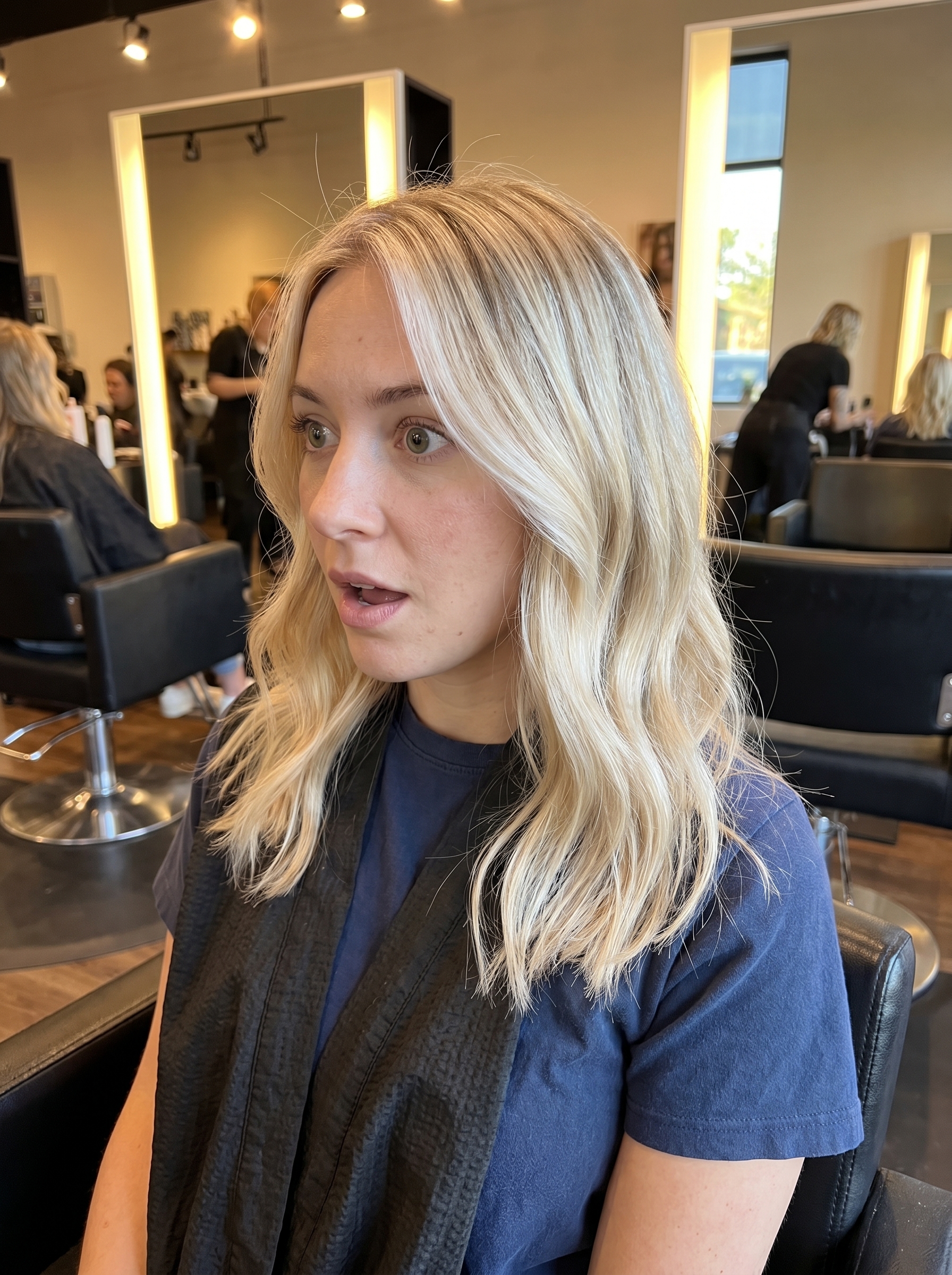 A close-up of sun-kissed scandi-swoosh blonde hair, revealing pale gold and baby blonde hues. This soft summer blonde hair 2026 style is perfect for an effortless vacation look.