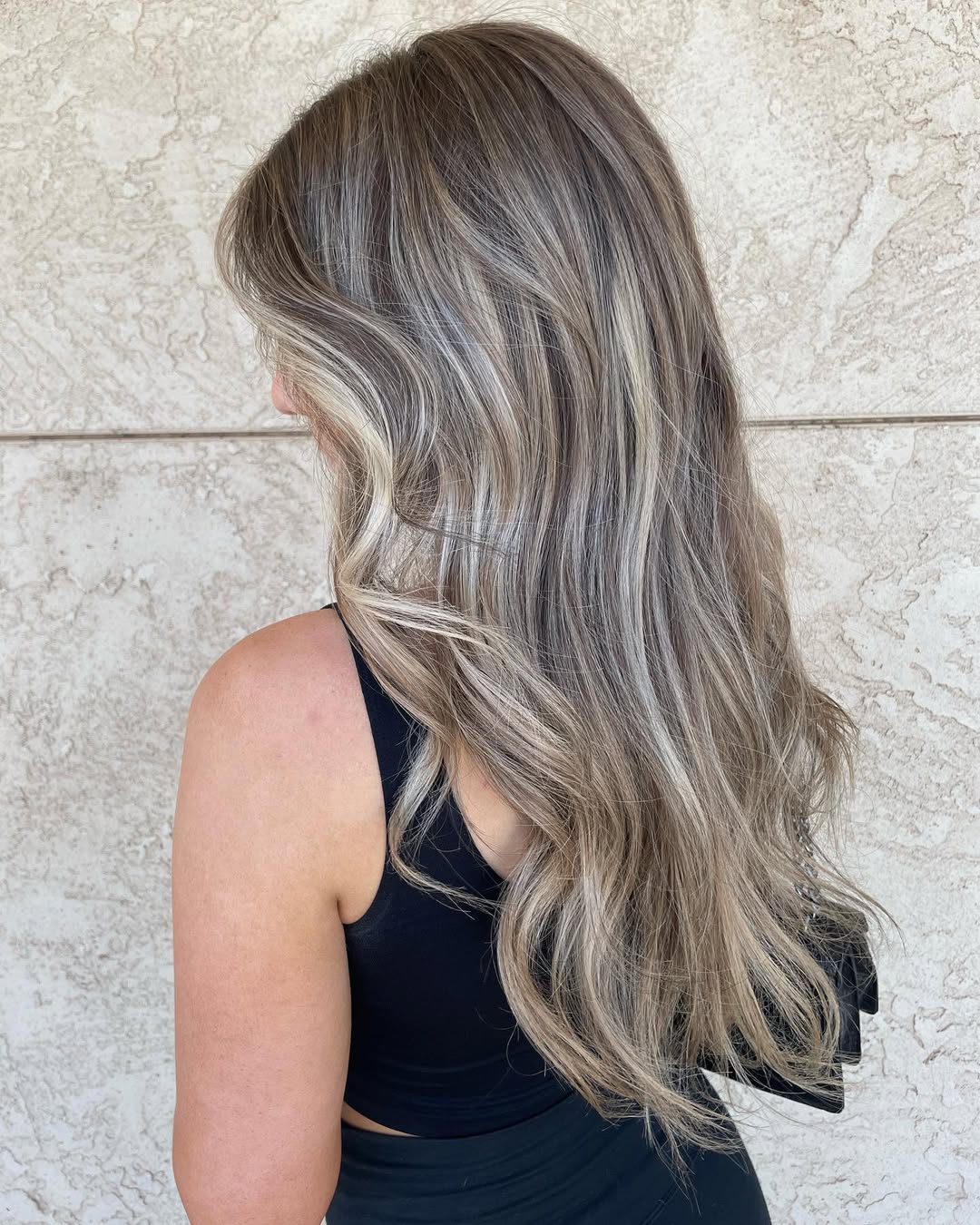 Woman with a chic soft summer hair color 2026, featuring golden blonde highlights expertly blended for a natural, sun-kissed effect, perfect for a casual day out.
