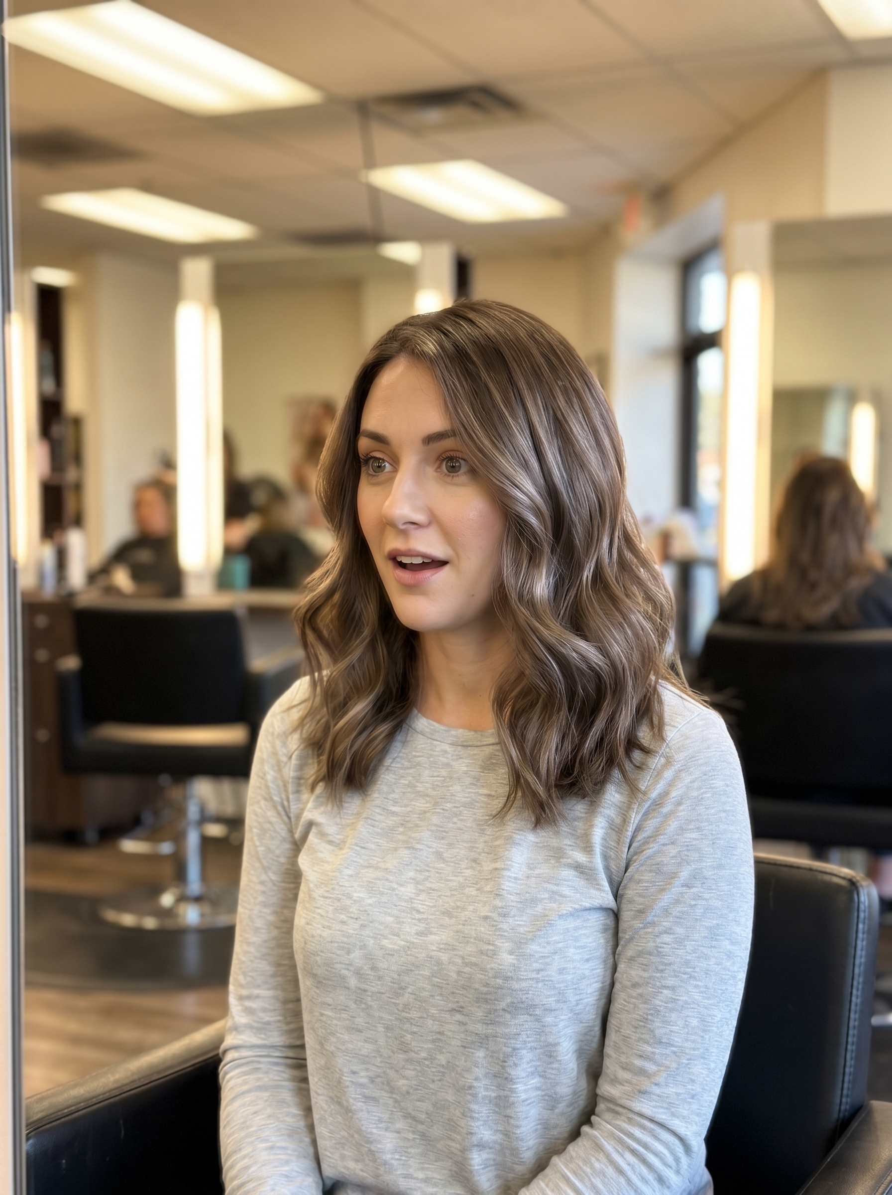 A refined iced chai brunette with a root tap, showcasing a natural soft summer hair color 2026. Features taupe, ash brown, and cool tan tones, suitable for everyday, work, and special occasions.