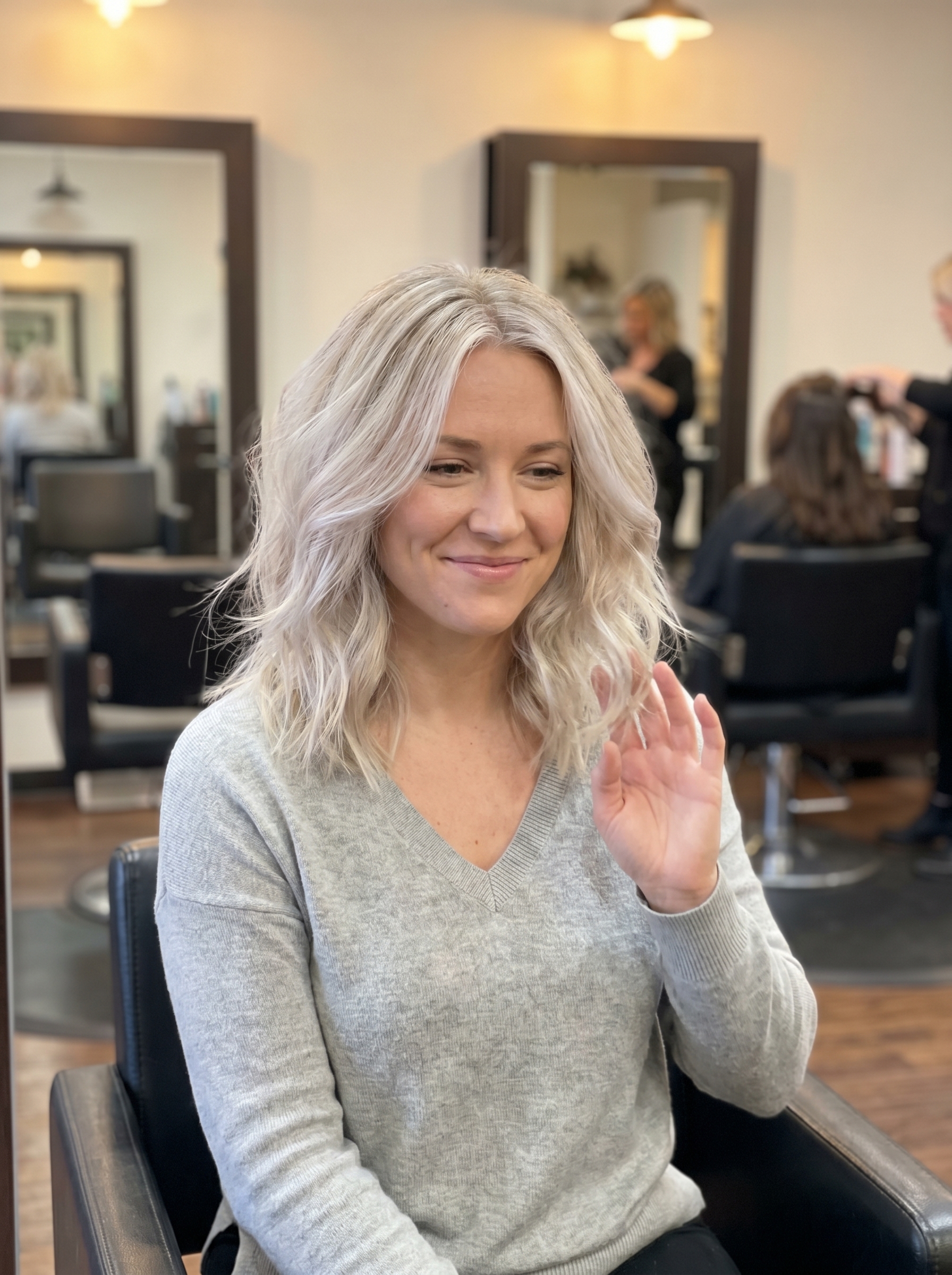 A model with natural and bright muted blonde face-frame highlights, a youthful soft summer hair color 2026. Features cool vanilla and pale ash tones around the face, ideal for an everyday look.