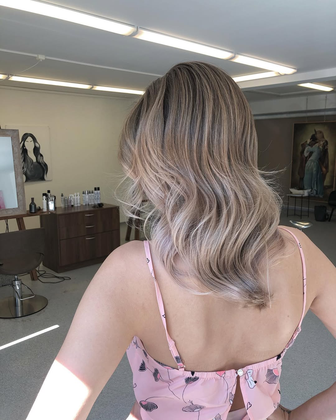 Close-up of a woman with a natural, sun-kissed soft summer hair color, likely a warm blonde or light brown hue. Her hair has subtle highlights that frame her face beautifully, giving her a glowing appearance, perfect for 2026 trends.