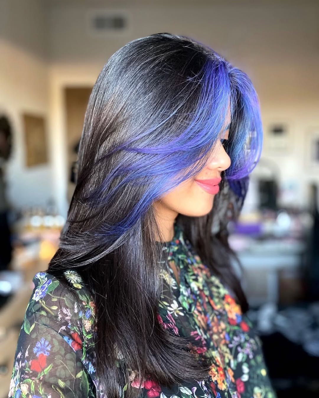Woman with long, wavy blonde hair styled in loose beach waves, perfect for summer hair ideas. Her hair has subtle highlights, flowing over her shoulders, framing her face for a casual yet chic look.