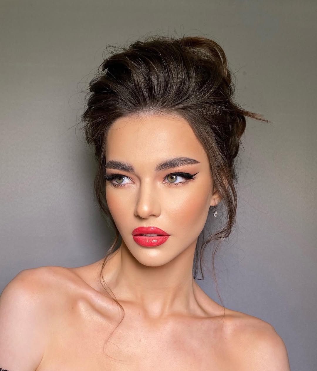 Beautiful woman with long, shiny blonde hair styled in loose beach waves, perfect for summer hairstyles 2026. She wears a casual white top, ideal for a relaxed day out.