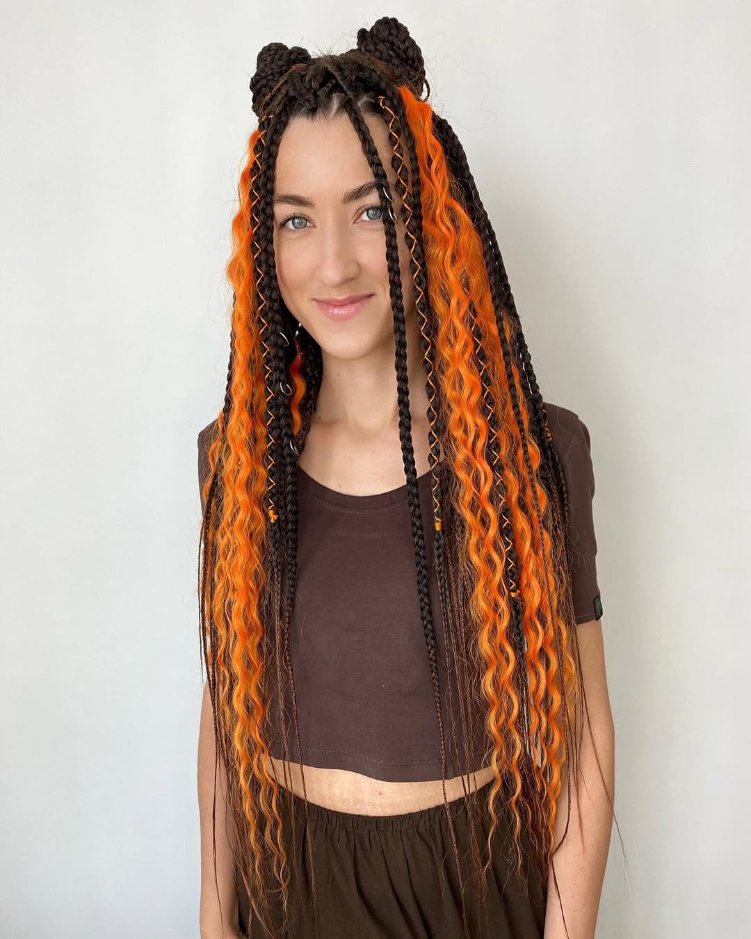 Close-up of a woman with a half-up romantic braid, perfect for summer hairstyles 2026. Her light brown hair is intricately woven, showcasing soft, face-framing tendrils and a sophisticated yet effortless style.