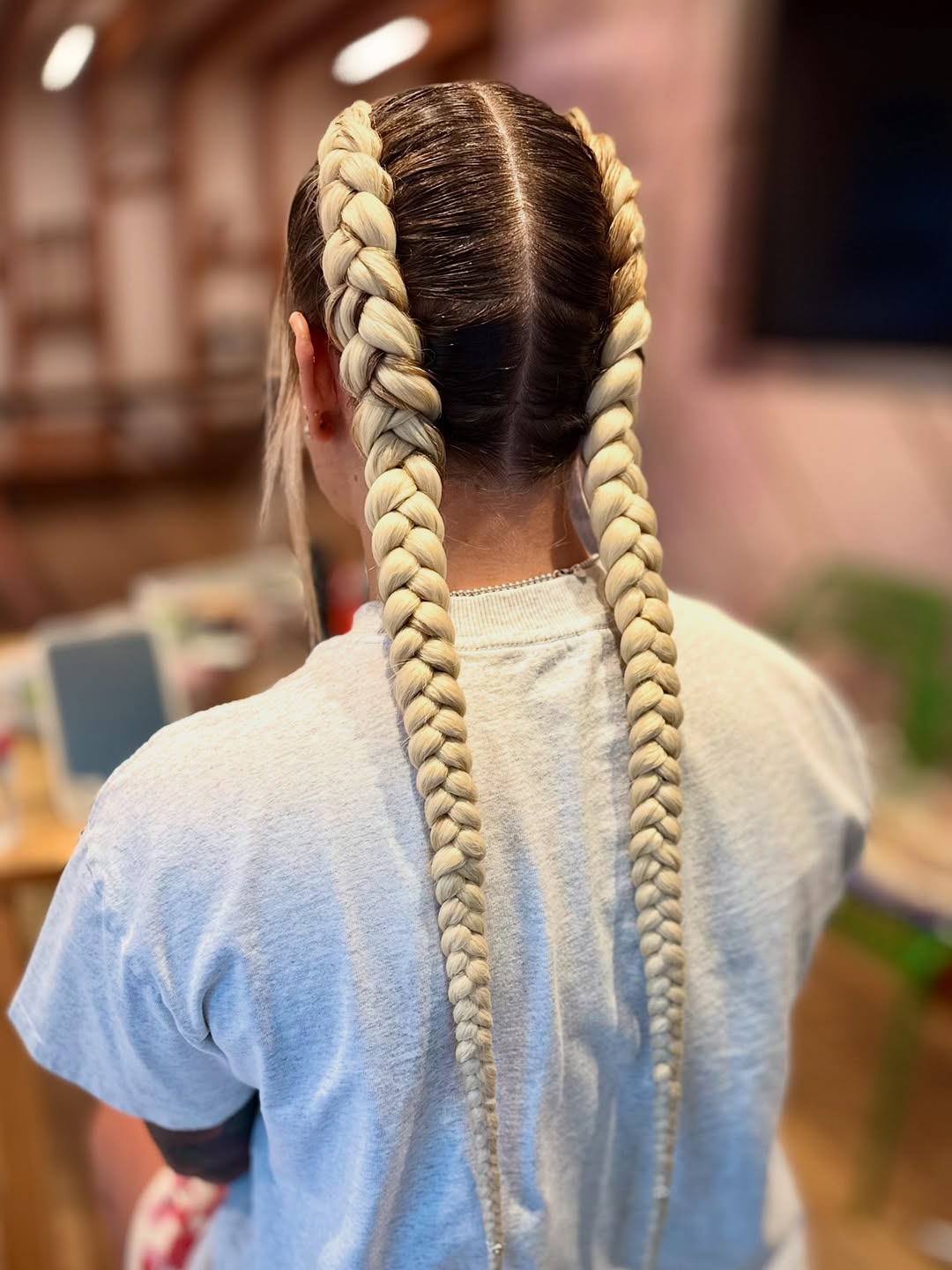 Close-up of a woman showcasing beautiful summer hairstyles braids 2026, featuring chic cornrows flowing into long, styled box braids, perfect for a casual sunny day. Her hair is a rich dark brown.