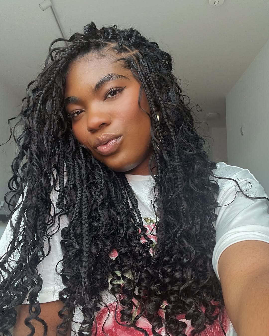 Beautiful woman with long, dark hair styled in intricate cornrow braids for summer, showcasing a trendy and protective summer hairstyles braids 2026 look. She's dressed in a chic, lightweight top, perfect for warm weather.