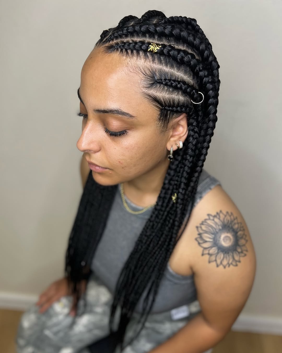 Close-up of a woman with beautiful summer hairstyles braids 2026, featuring neat cornrows cascading into long, wavy extensions.