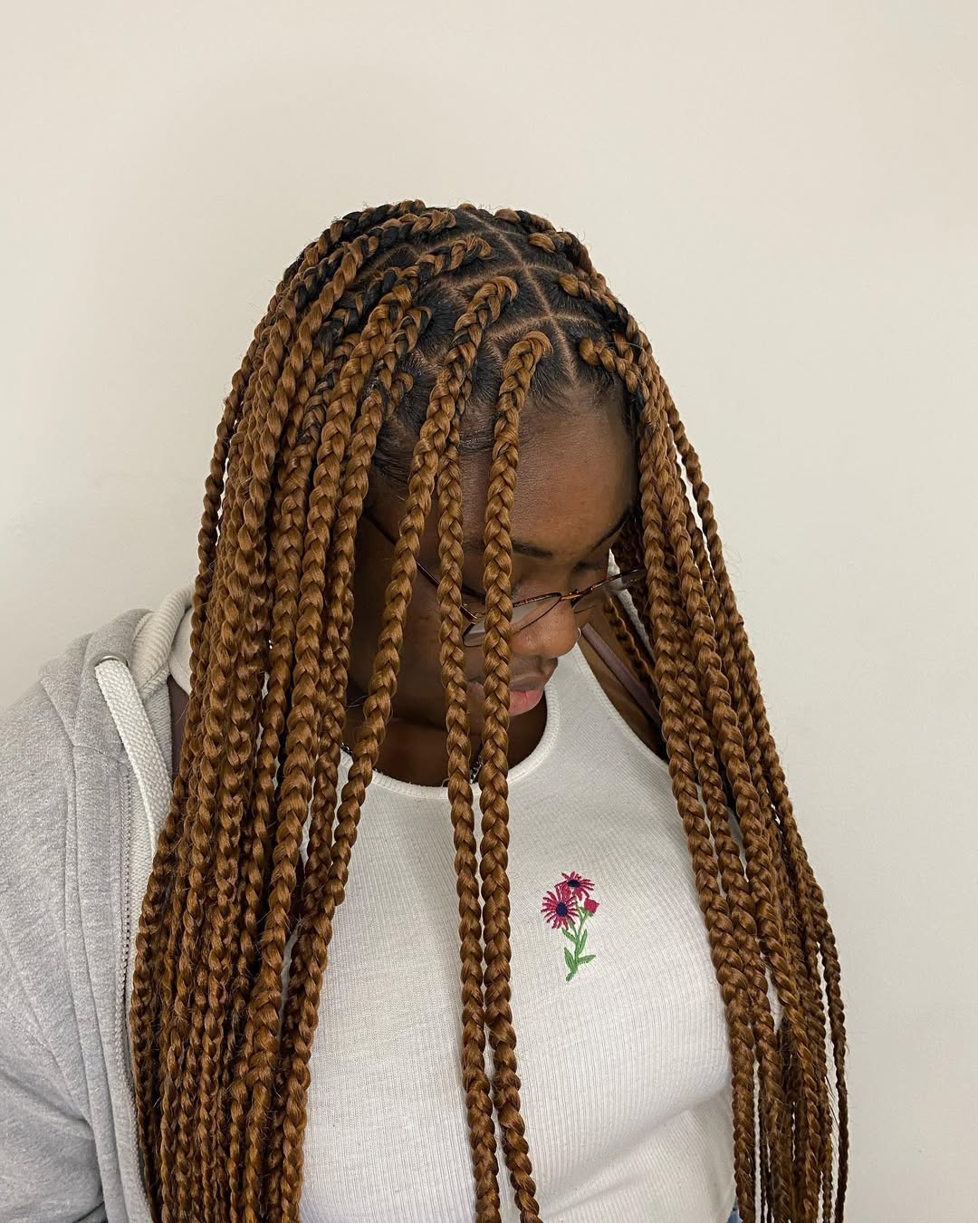 Close-up of a woman with intricate blonde summer hairstyles braids 2026, featuring a fishtail braid and small accent braids, perfect for a beach day.