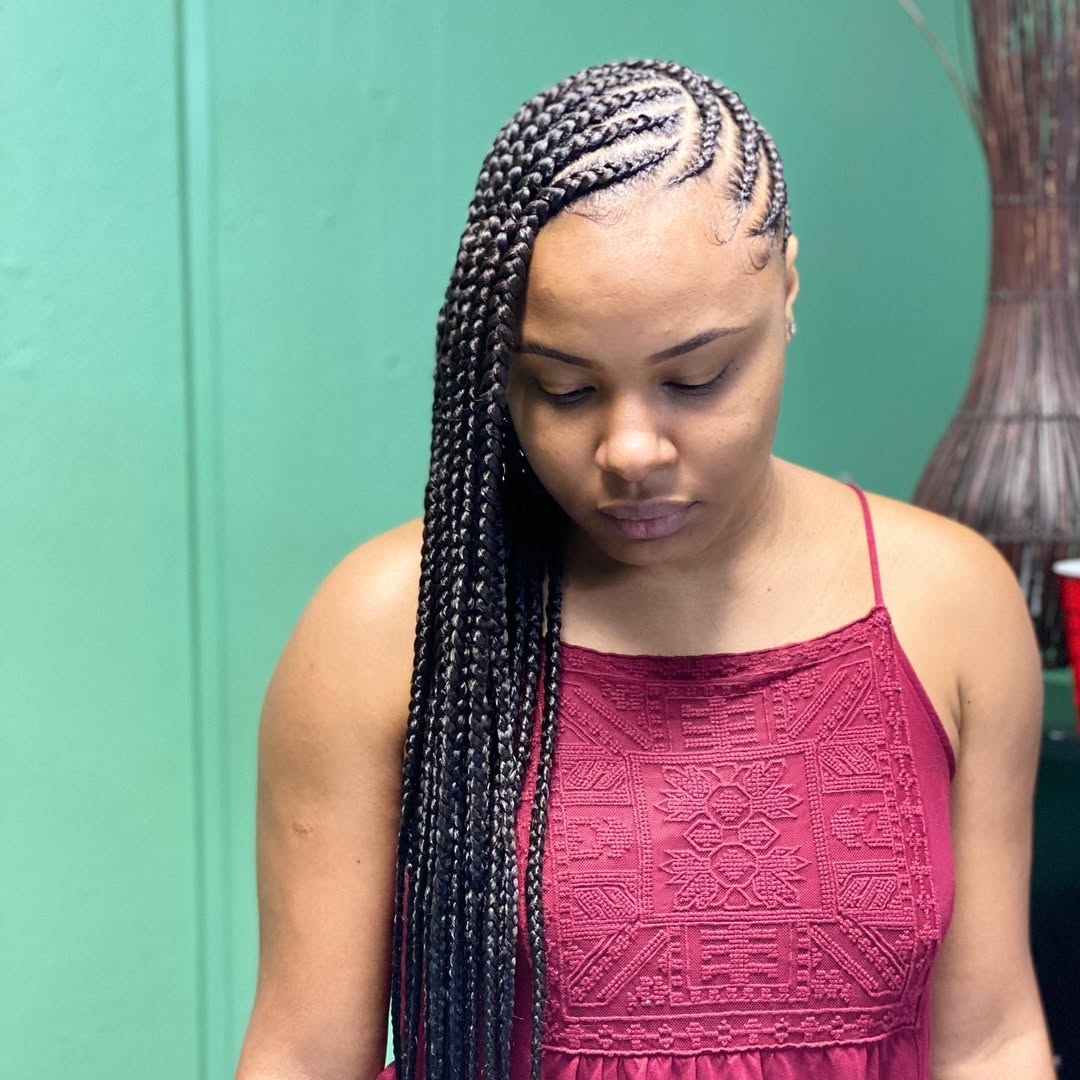 Close-up of a woman with long brunette hair styled in intricate summer hairstyles braids 2026, featuring delicate cornrows leading into a voluminous fishtail braid, perfect for a beach day.