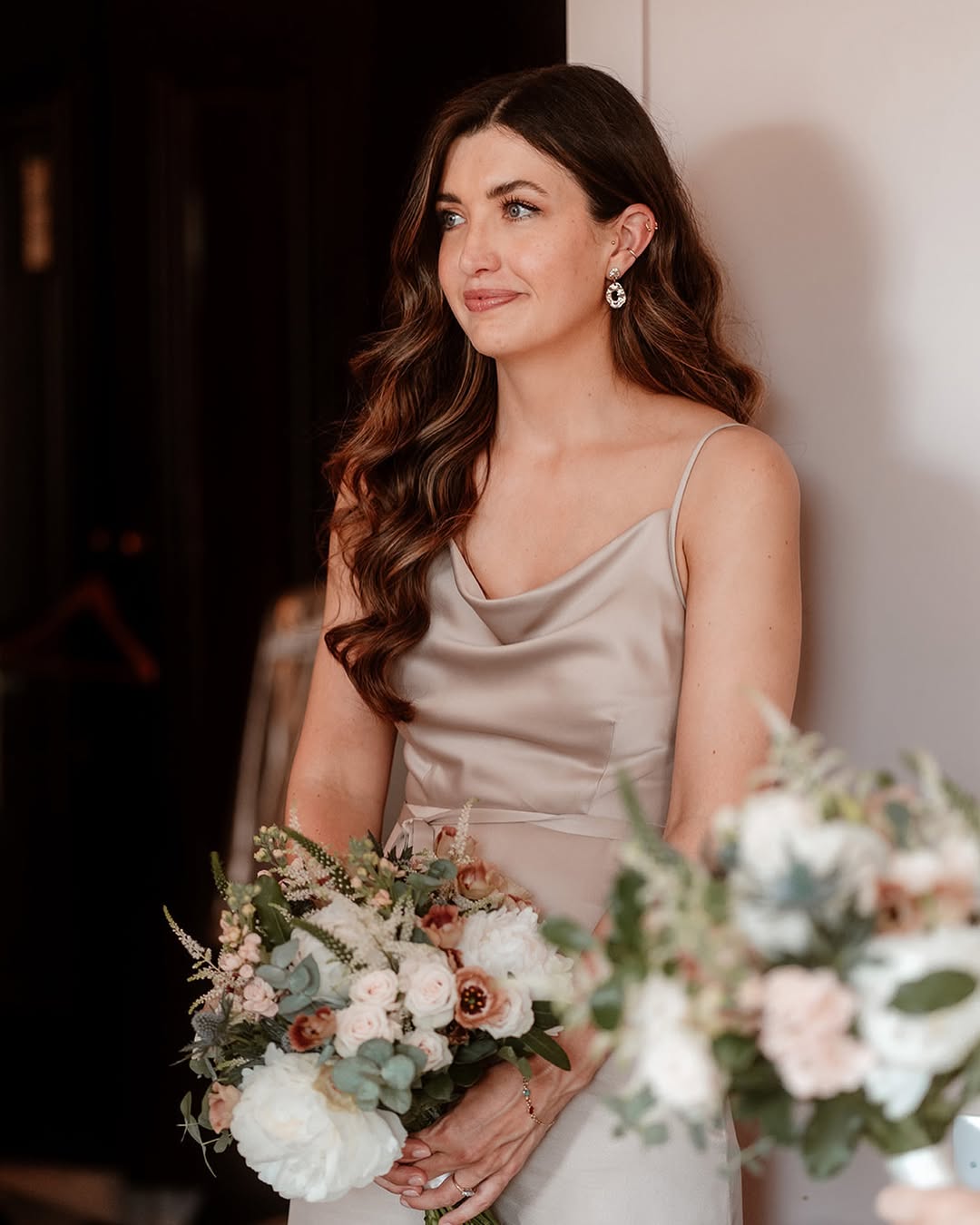 Beautiful blonde woman sporting a sleek, low bun with delicate pearl hair accessories, perfect for summer wedding guest hair 2026 at a formal event.
