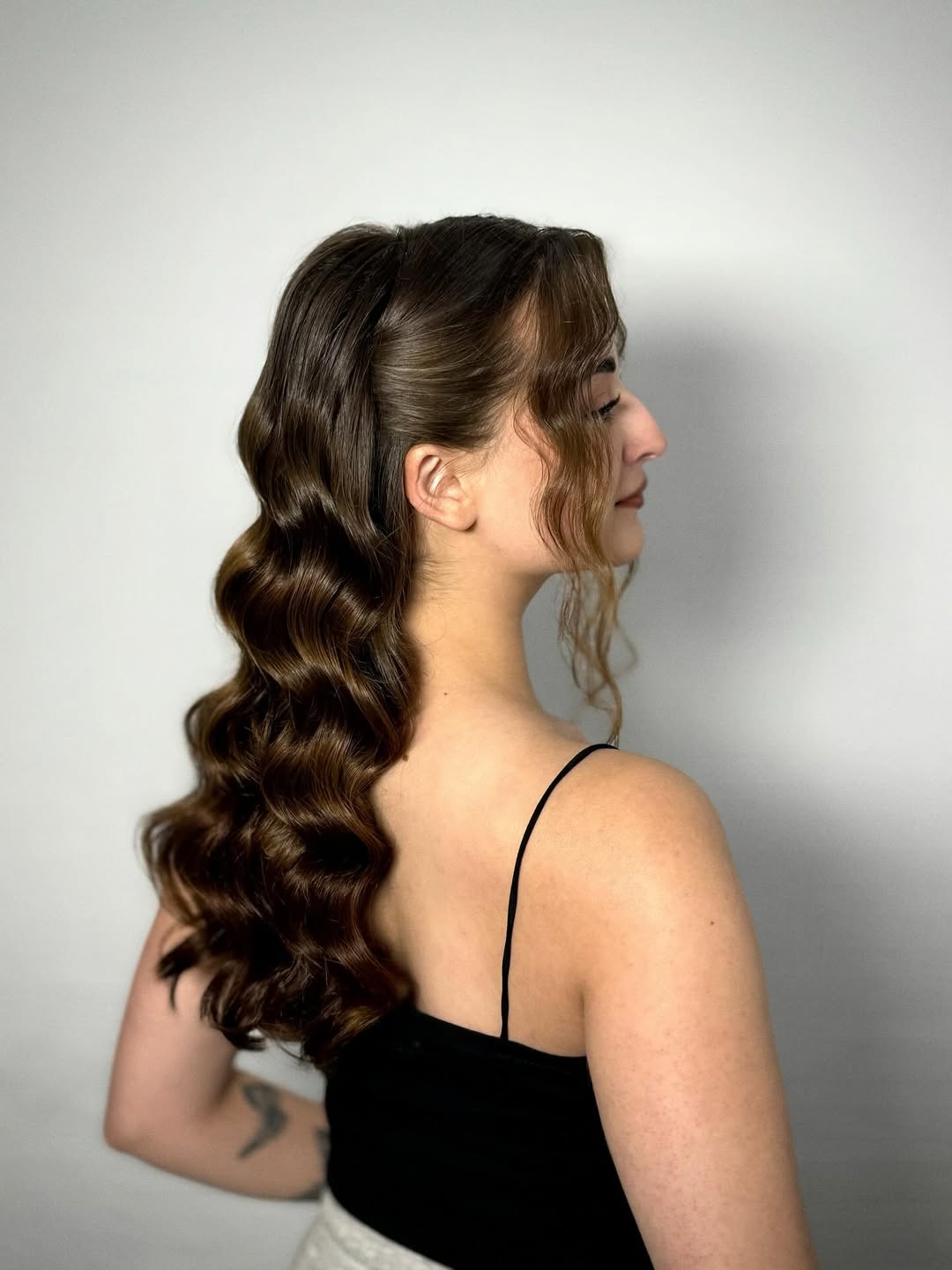 Beautiful blonde woman with a messy bun, perfect for a summer wedding guest hair 2026. Her updo is chic and keeps her cool.