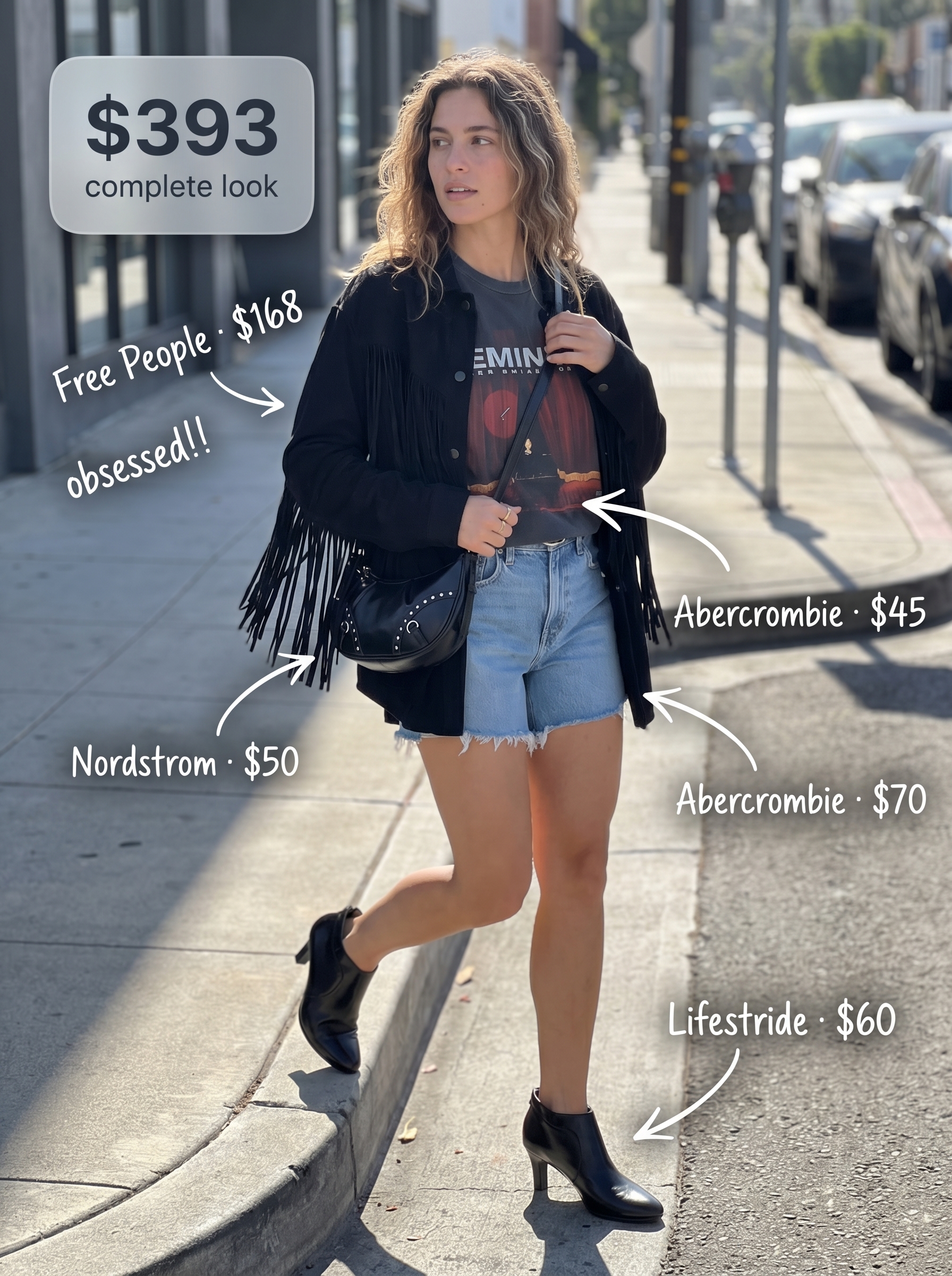 Edgy black faux suede fringe jacket with distressed denim shorts as part of western summer outfits for a concert. Graphic tee, studded bag, and ankle boots complete the cool look.