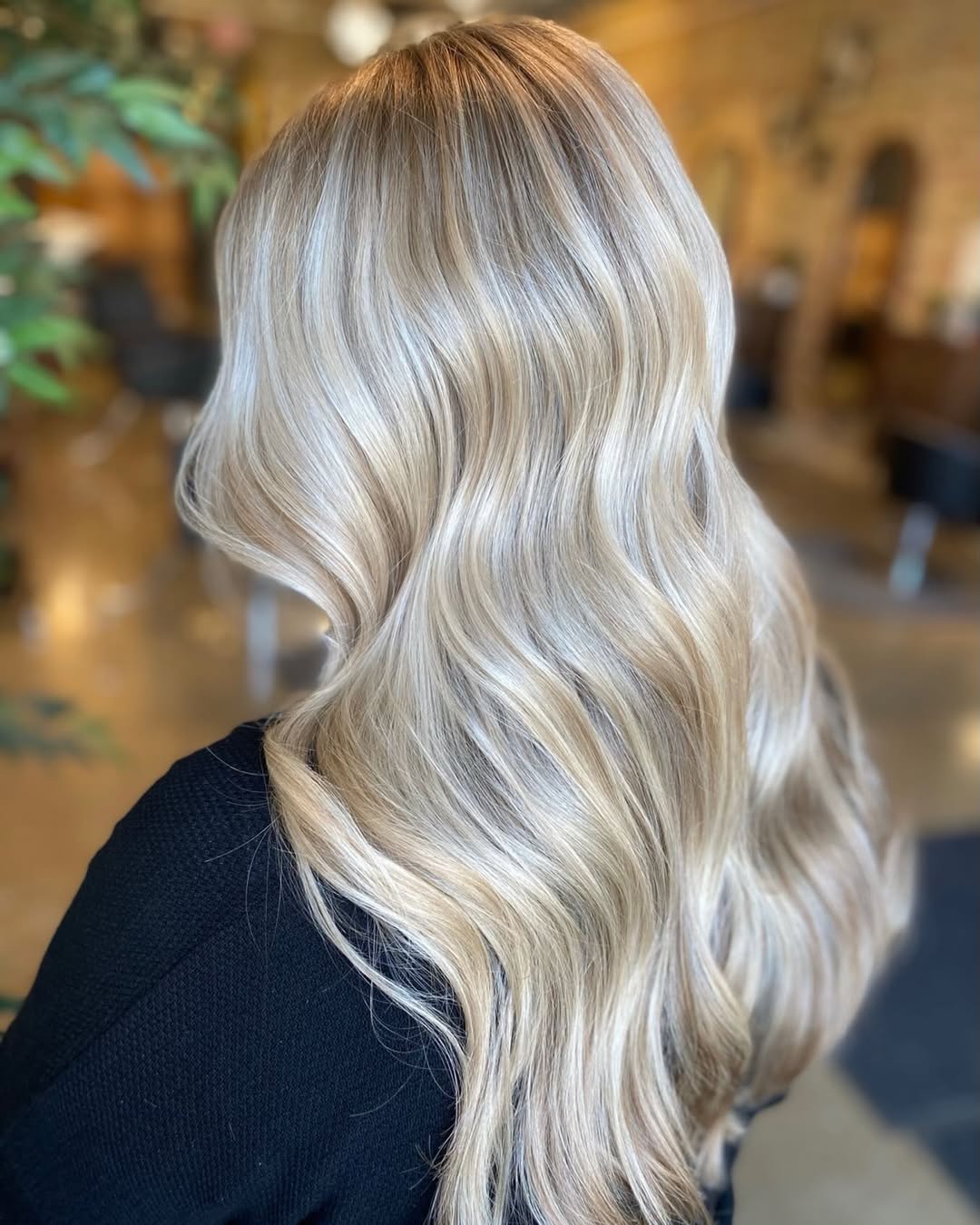 Close-up of a woman with radiant blonde hair inspo summer 2026, styled in soft waves, against a sunny outdoor backdrop, showcasing sun-kissed highlights perfect for warm weather.