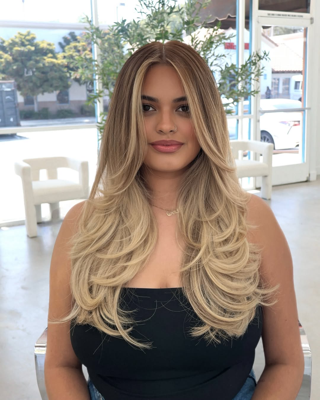 Close-up of a woman with long, sun-kissed blonde hair inspo summer 2026, styled in soft, natural waves, perfect for beach days or casual outings. Her hair has subtle highlights framing her face.