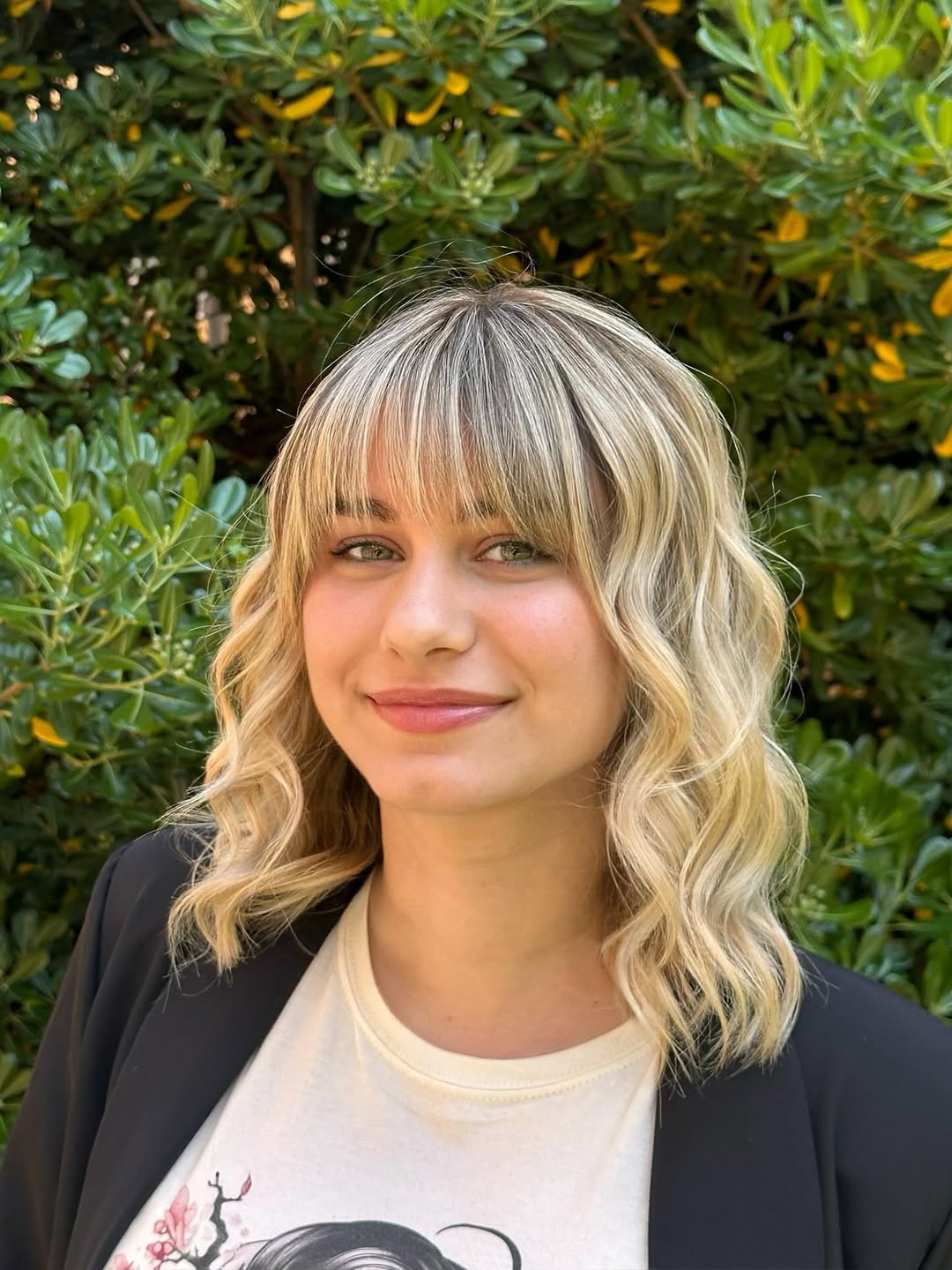 Close-up of a woman with vibrant blonde hair inspo summer 2026, styled in soft waves, accentuating bright highlights against a warmer base.