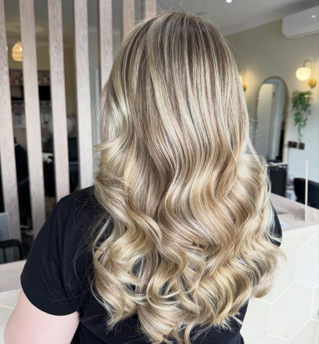 Close-up of a woman with long, sun-kissed blonde hair inspo summer 2026, styled in soft waves, suitable for a casual daytime look.