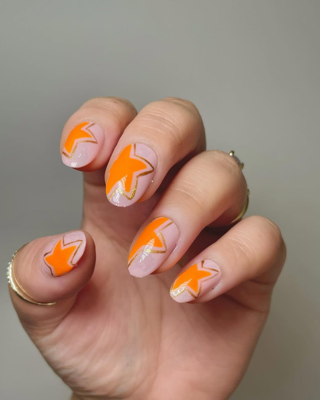 Bright Orange Starburst Squoval Nails with Gold Outline