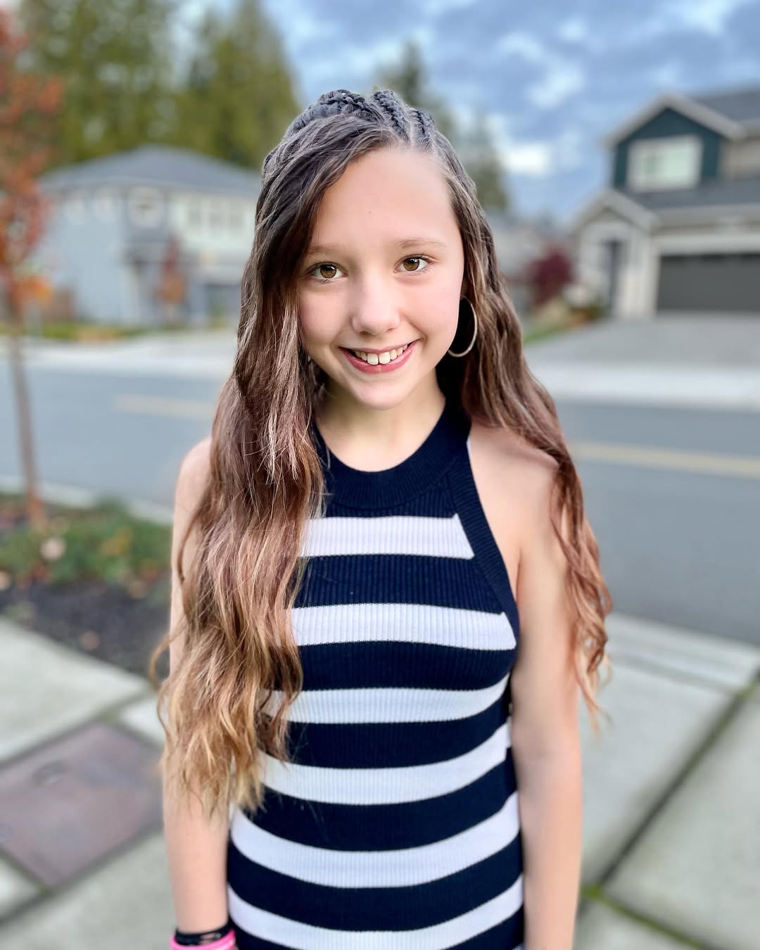 A teen with long waves and a braided half-up hairstyle, perfect for cute summer hairstyles for teens.