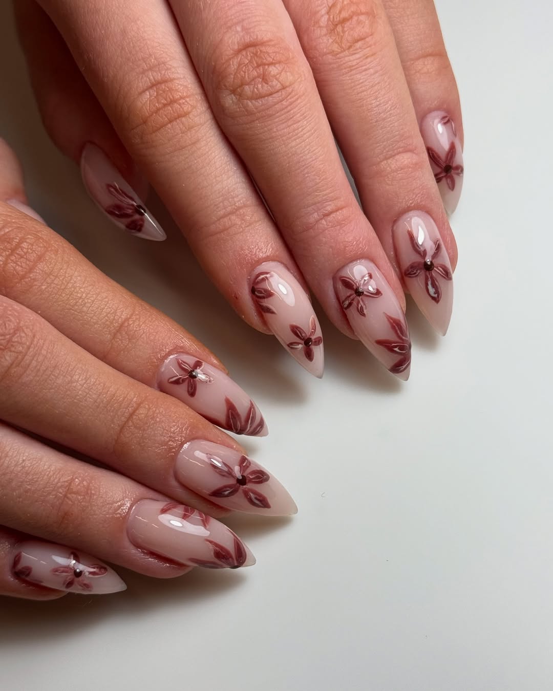 Glossy Nude Almond Nails With Burgundy Floral Art
