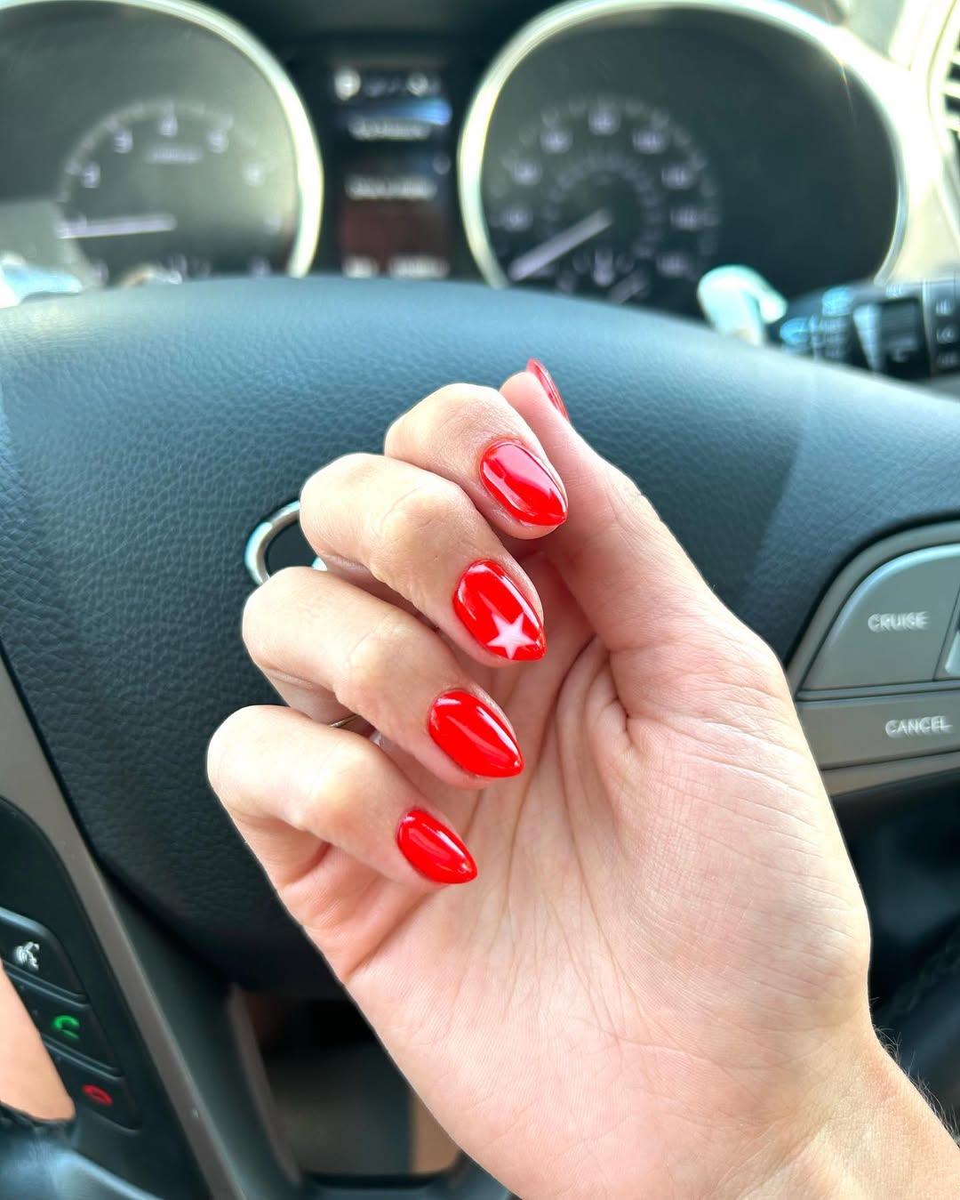 Glossy Red Almond Nails With White Star Accent