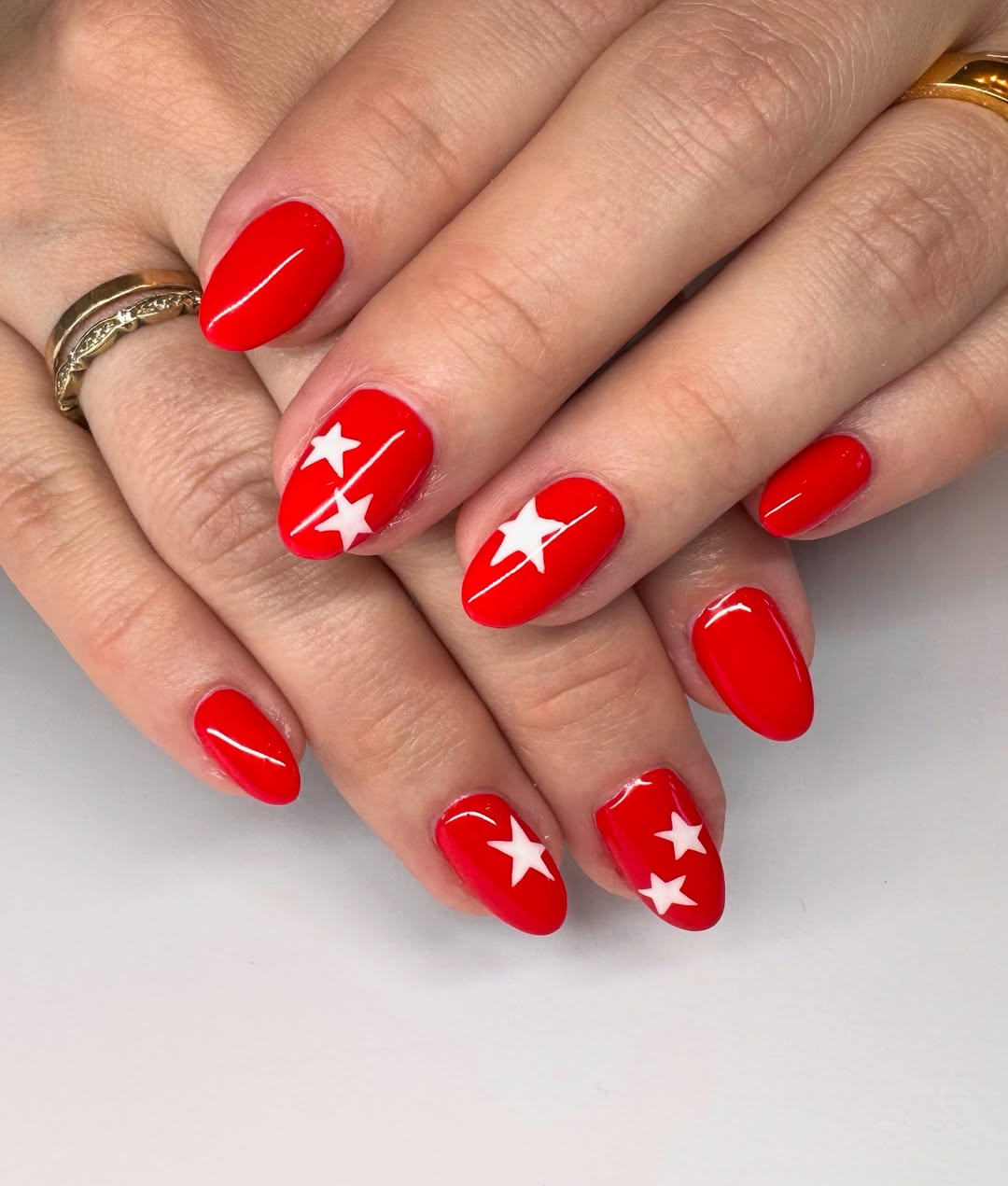 Glossy Red Almond Nails With White Stars