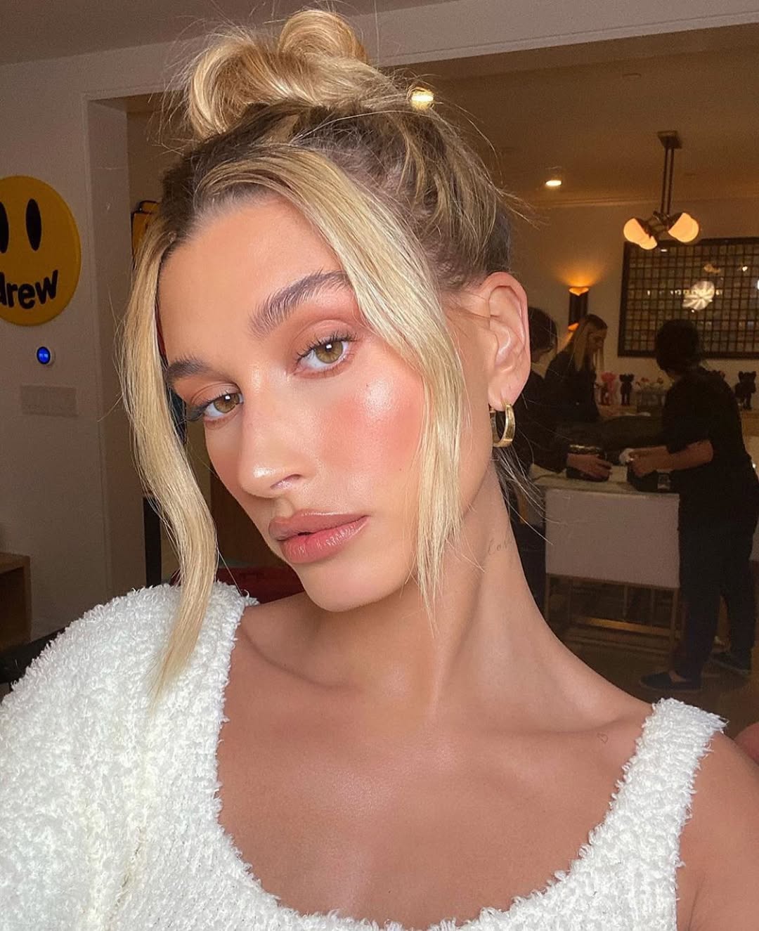 Blonde woman with a braided bun bun hairstyle, perfect for hot weather 2026. This elegant updo keeps hair off the neck, ideal for summer events.