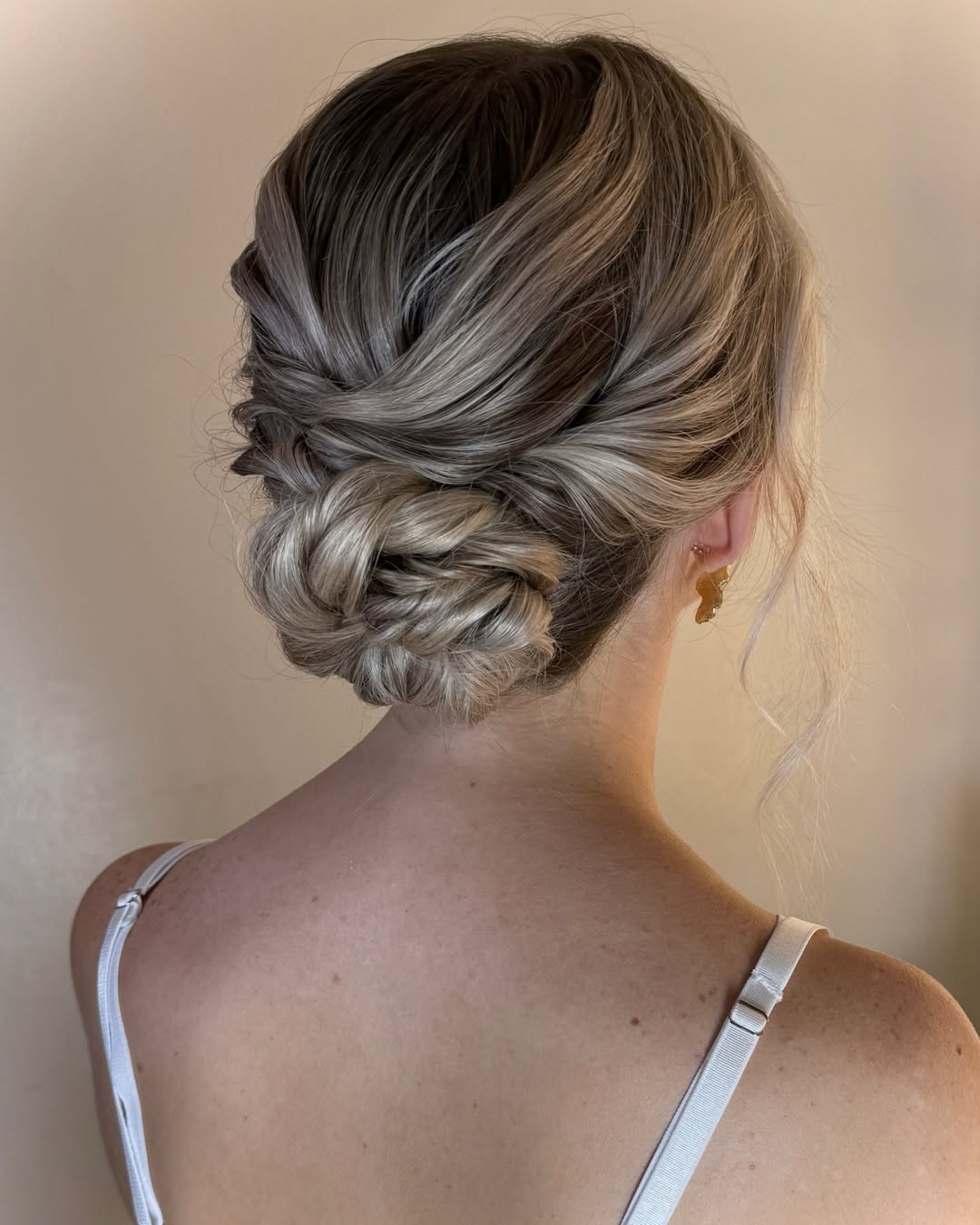 A woman wears a sleek, high ponytail with face-framing tendrils, perfect for showcasing hairstyles for hot weather 2026. This updo keeps hair off the neck in a stylish way.
