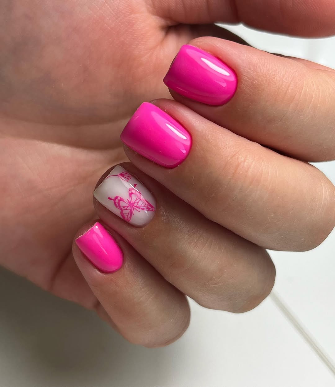 Hot Pink Glossy Squoval Nails With Butterfly Accent