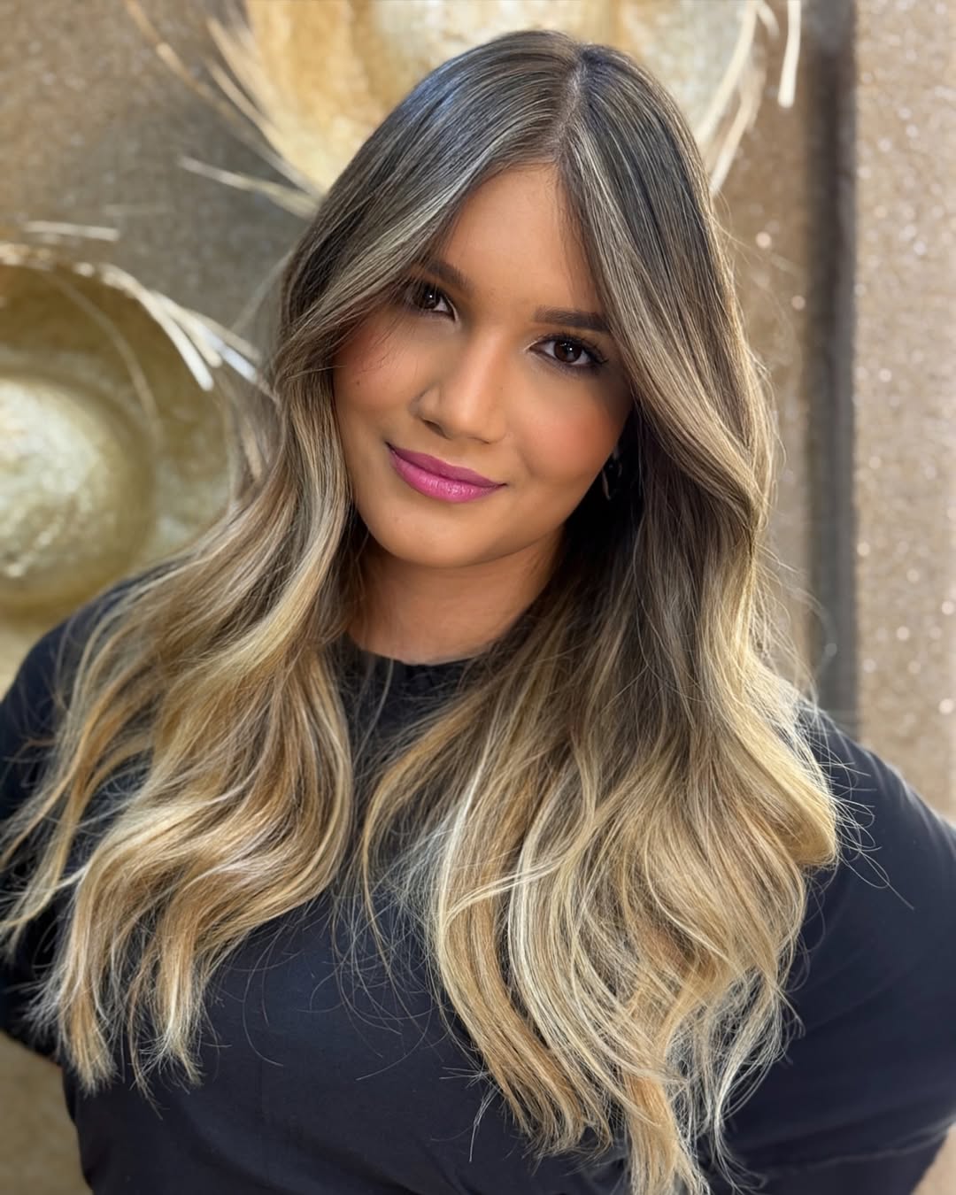 Close-up of a woman with soft summer blonde hair styled in loose waves, paired with a subtle, glowing makeup look ideal for 2026 trends.