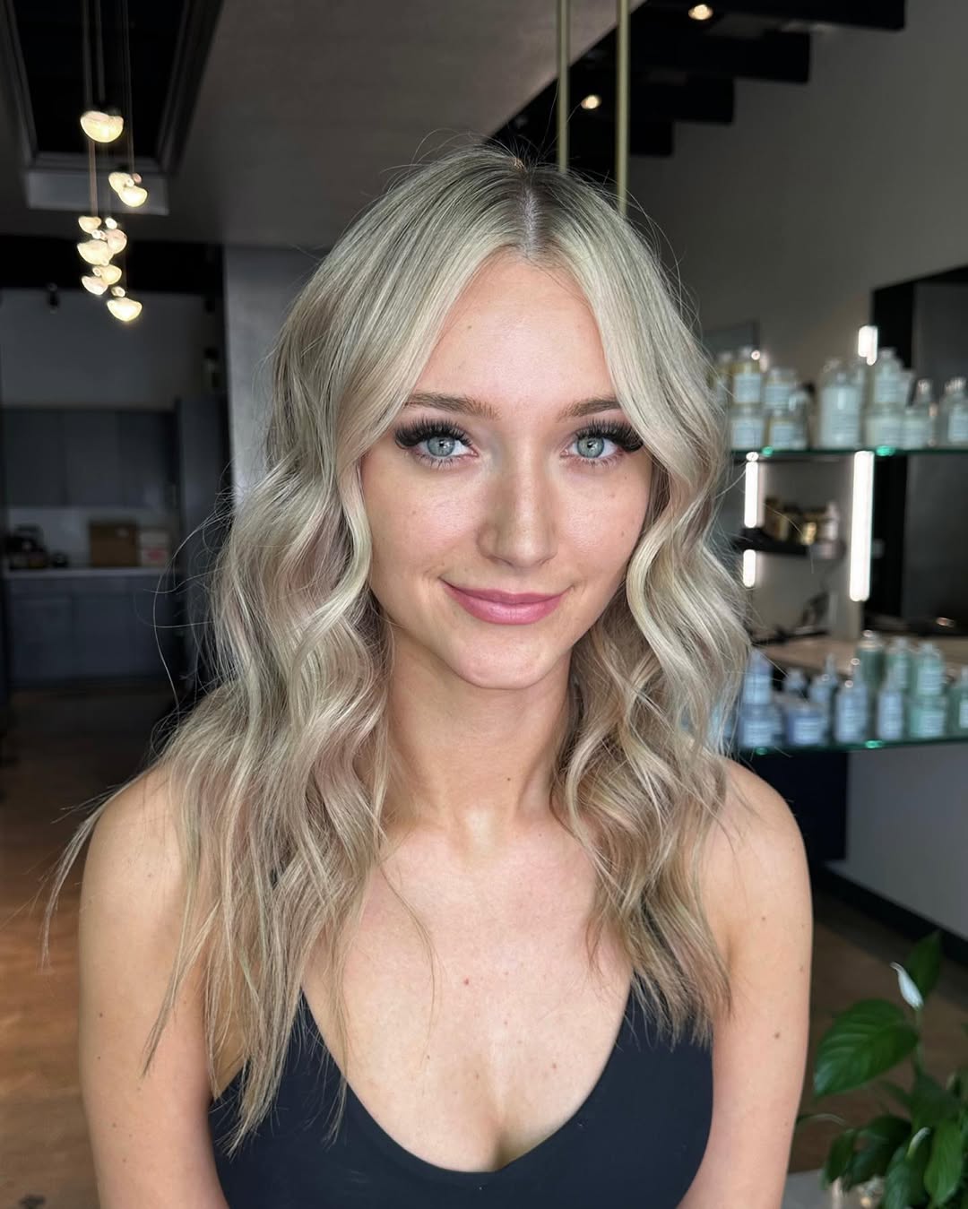 Close-up of a woman with beautiful soft summer blonde hair styled in loose waves, showcasing a natural, sun-kissed look. Perfect for a chic casual outing.