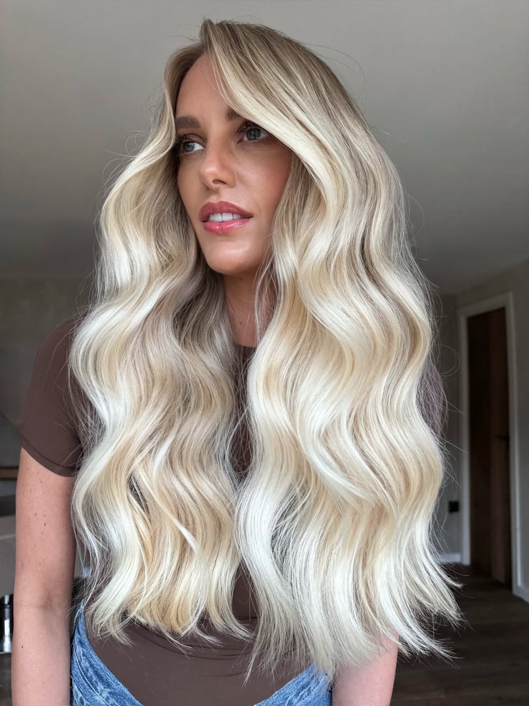 Close-up of a woman with stunning soft summer blonde hair 2026, featuring subtle, natural-looking highlights and lowlights that frame her face beautifully. Her hair appears healthy and perfectly styled.